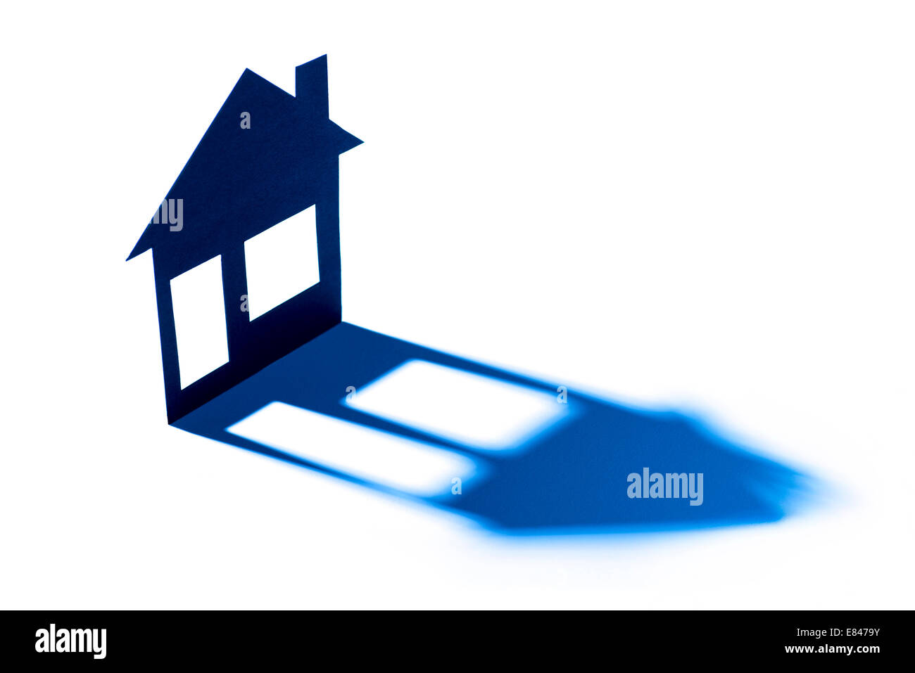 Abstract model of a house casts a long shadow. Stock Photo