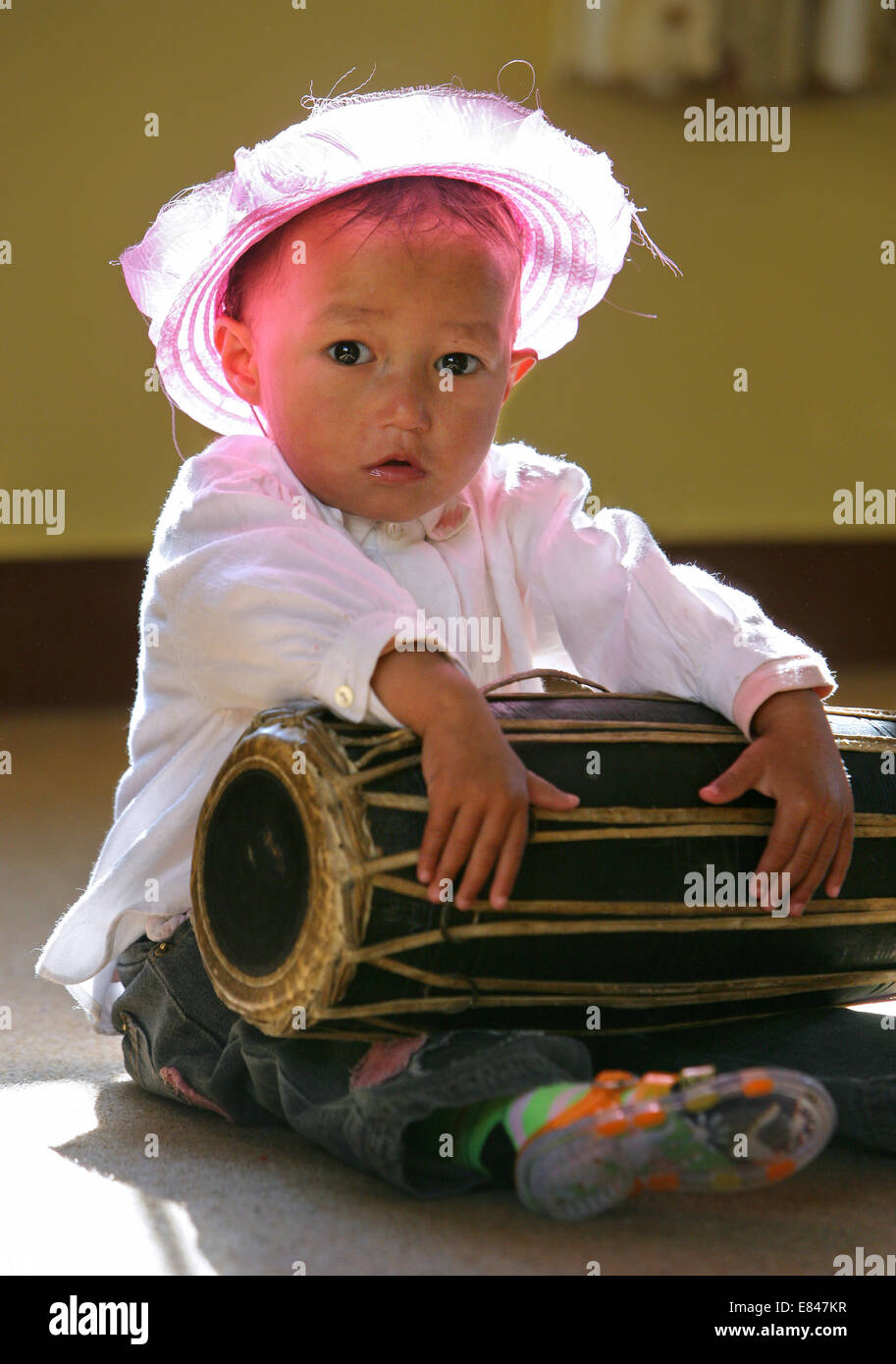 Nepal, Kathmandu, baby girl with drum in an orphanage Stock Photo Alamy
