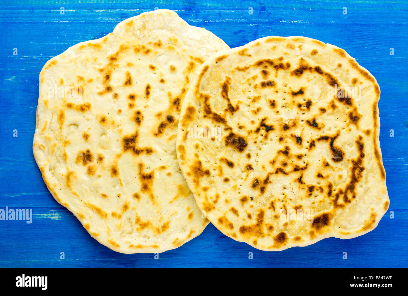 Pita bread, flat bread, pita, tortilla on a blue wooden background
