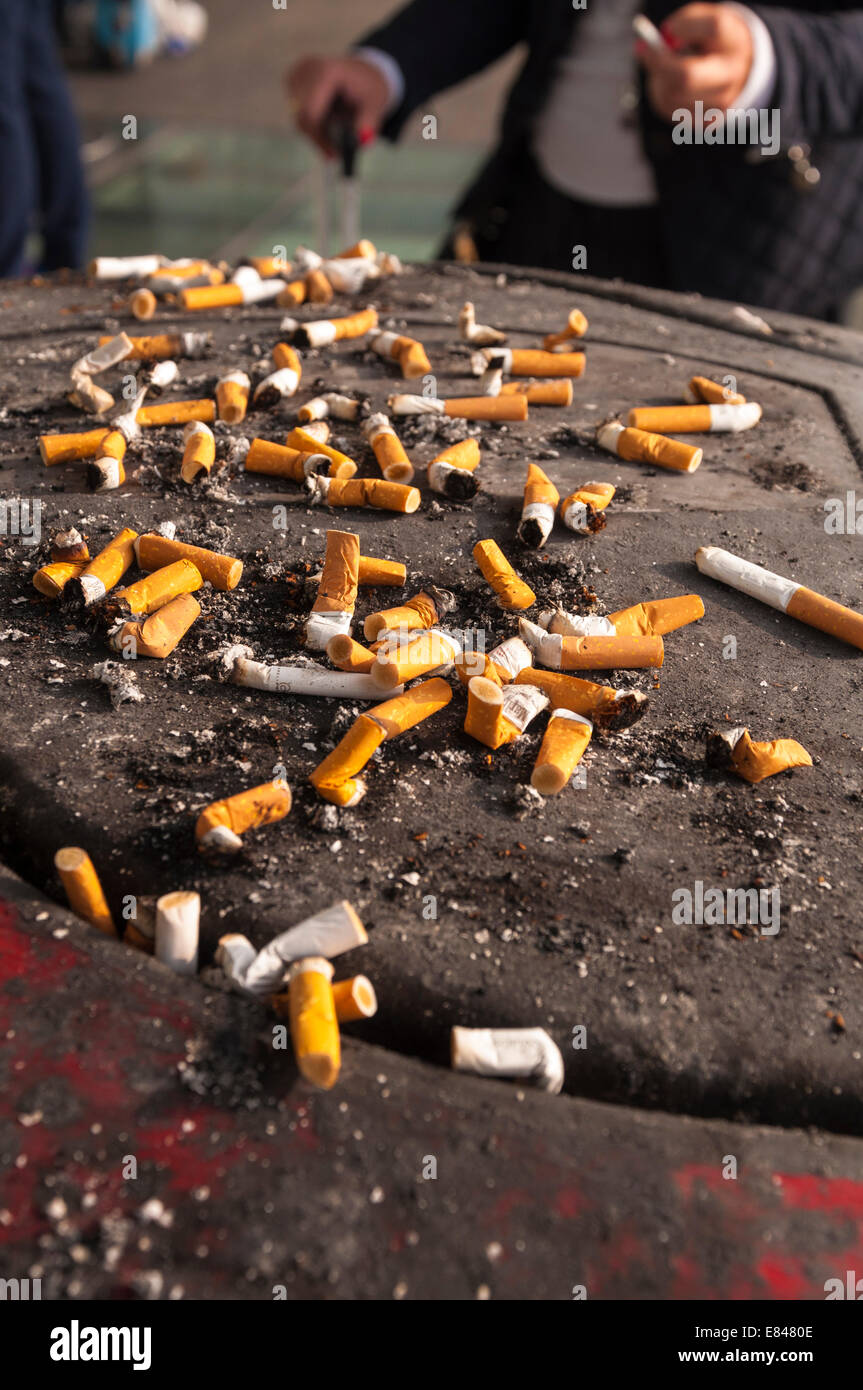 Cigarette butts left by smokers outside Stansted airport terminal Stock