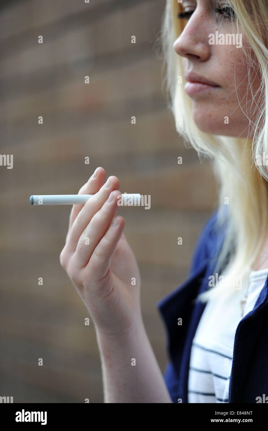 A girl holds a e-cigarette in her hand. Stock Photo