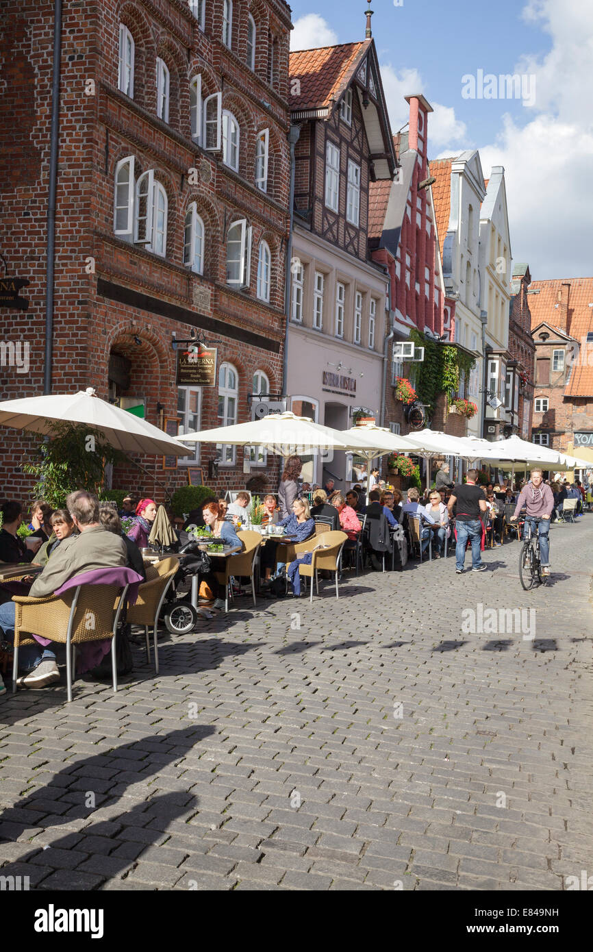 Am Stintmarkt with people sitting outside restaurants, Luneburg, Lower Saxony, Germany Stock Photo