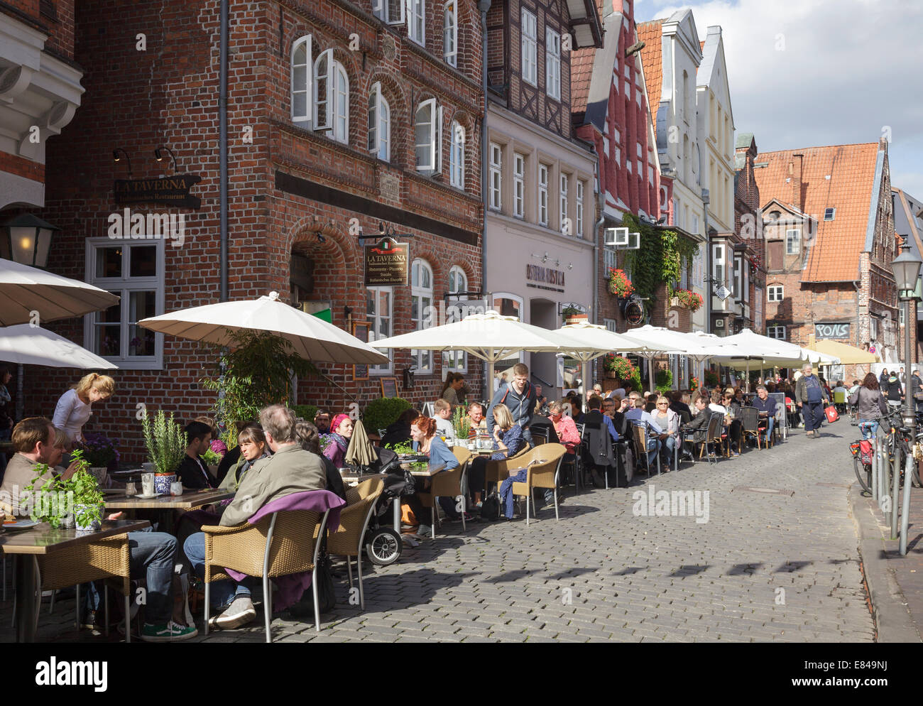 Am Stintmarkt with people sitting outside restaurants, Luneburg, Lower Saxony, Germany Stock Photo
