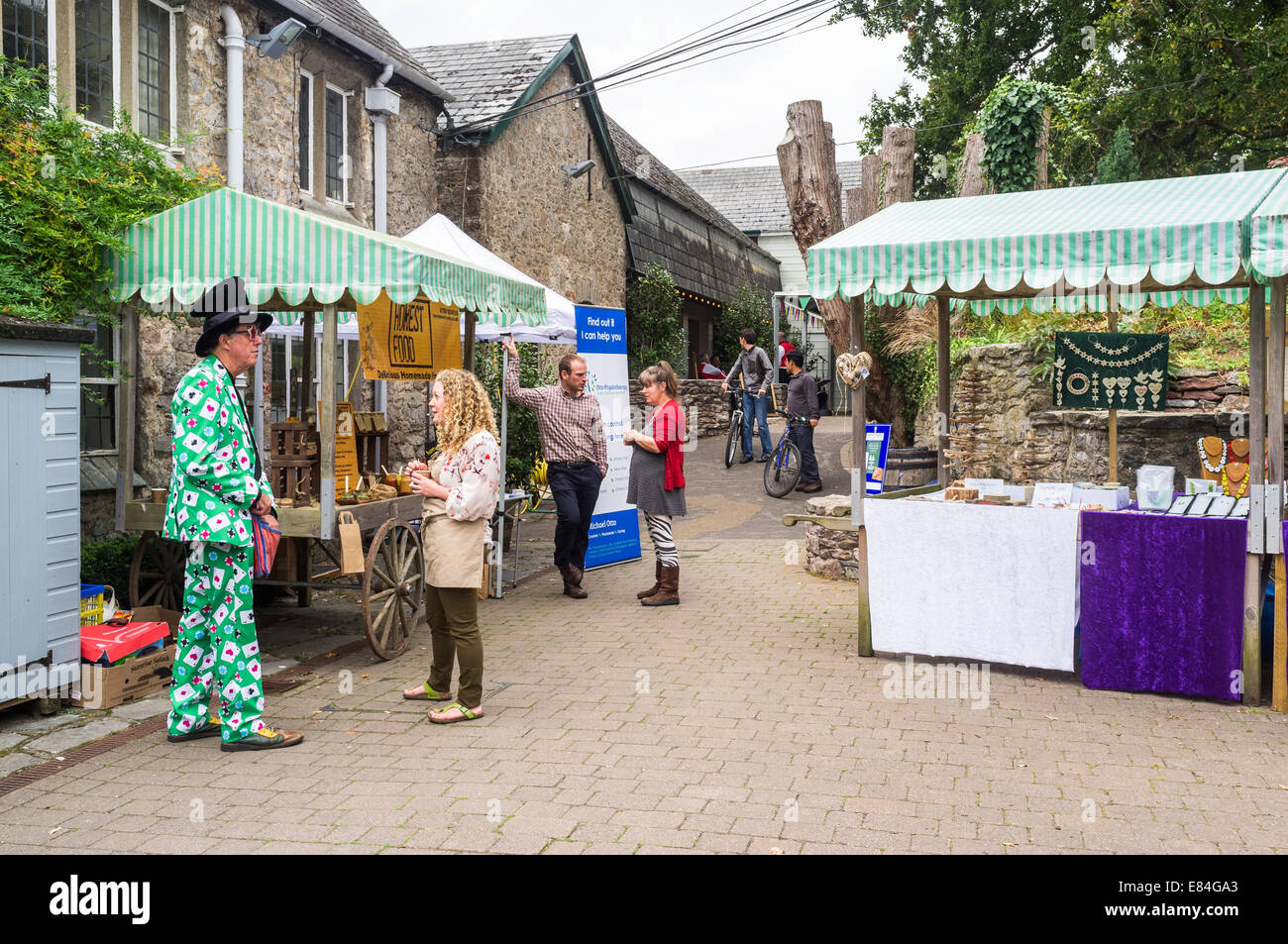 Dartington Devon England. A magician wearing a green suit decorated with Aces from a card deck and gambling chips. Stock Photo