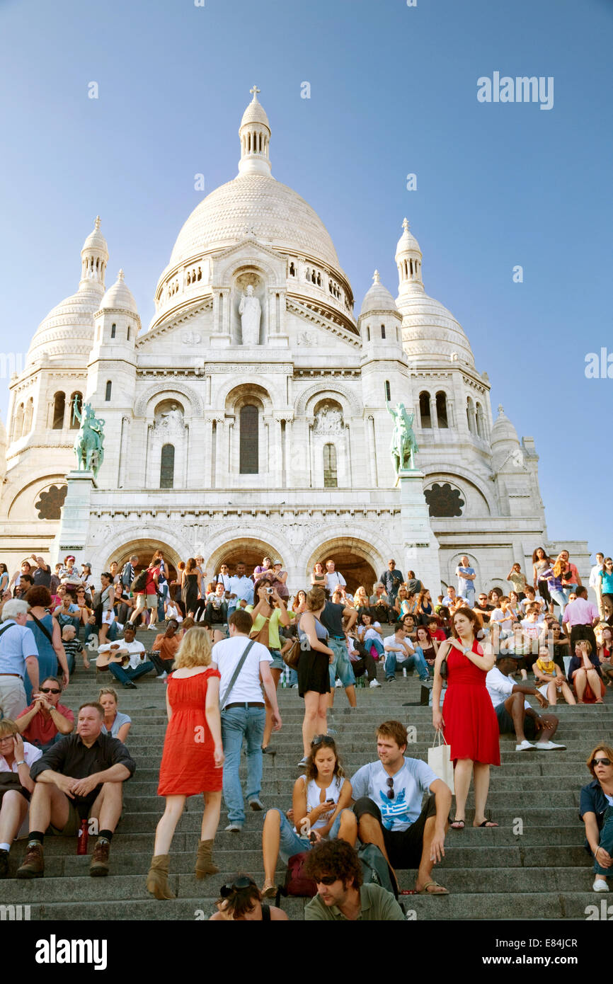 People - tourists sitting on the steps of Sacre Coeur Church in the evening, Montmartre, Paris, France Europe Stock Photo