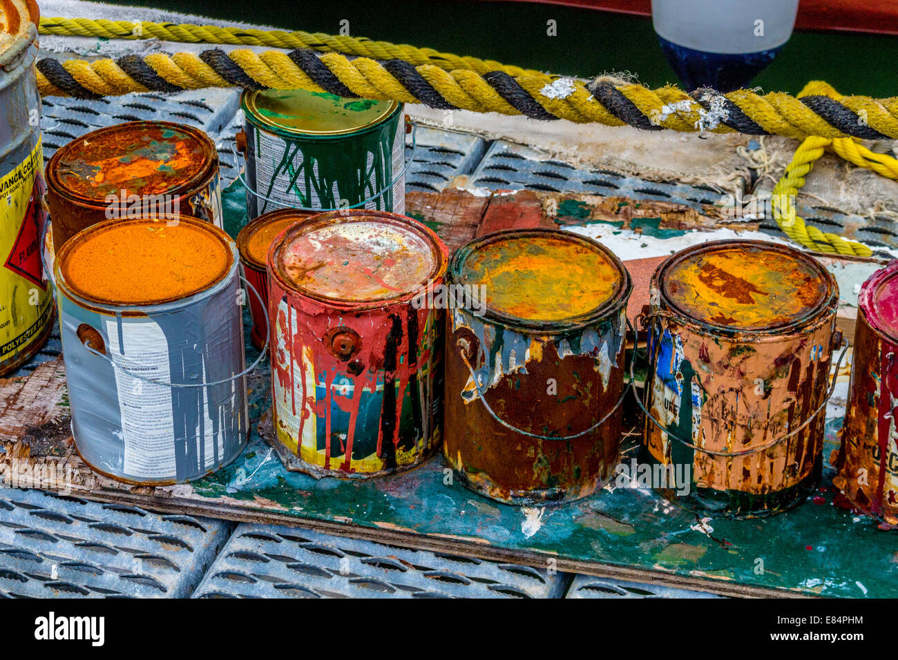 Colorful rusty paint cans on the dock. Stock Photo
