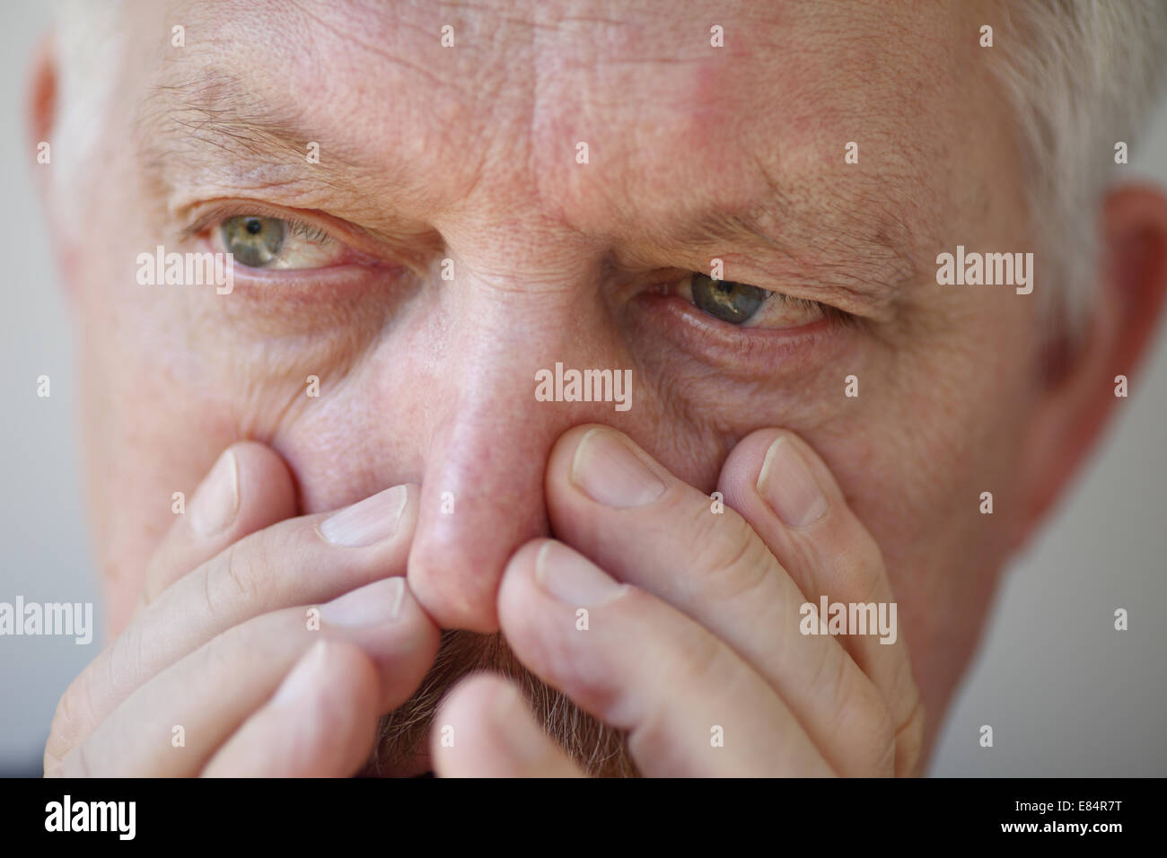 A man suffers from a stuffy nose. Stock Photo