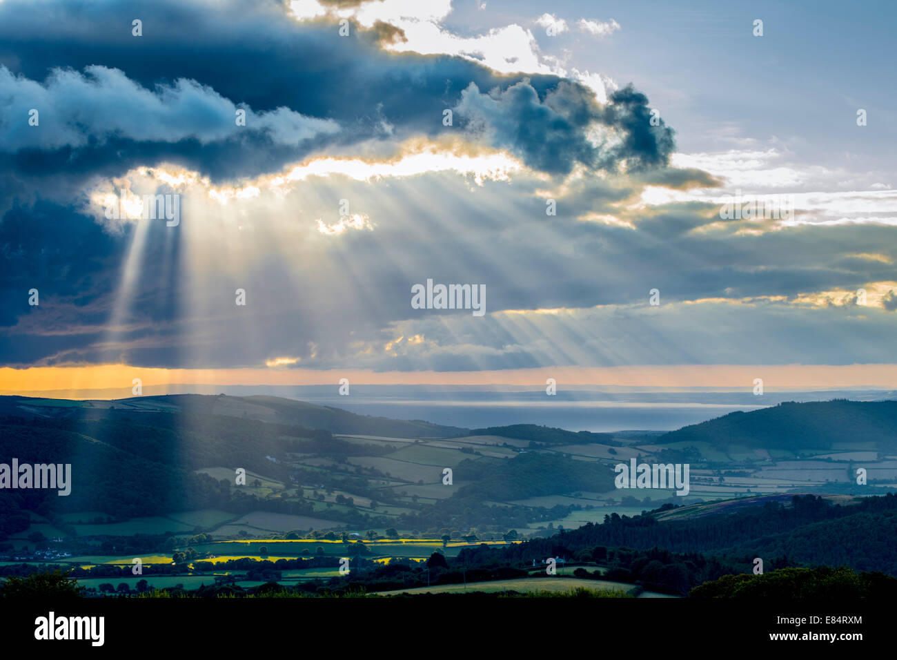 Shafts of light break through the cloud layer over Exmoor, bringing the hope of fine weather. Stock Photo