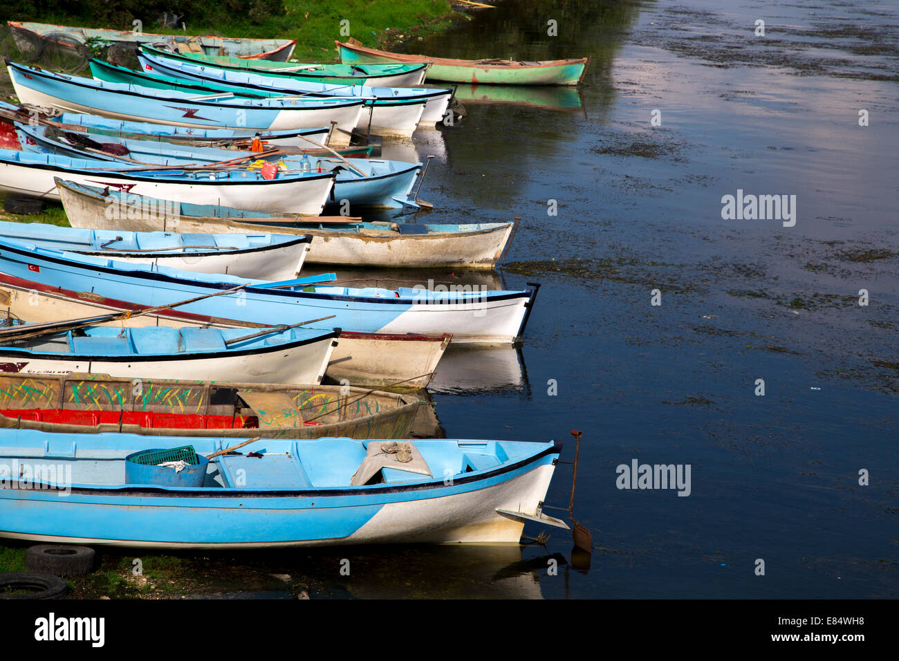 Group of fishing boats aligned near lake Stock Photo