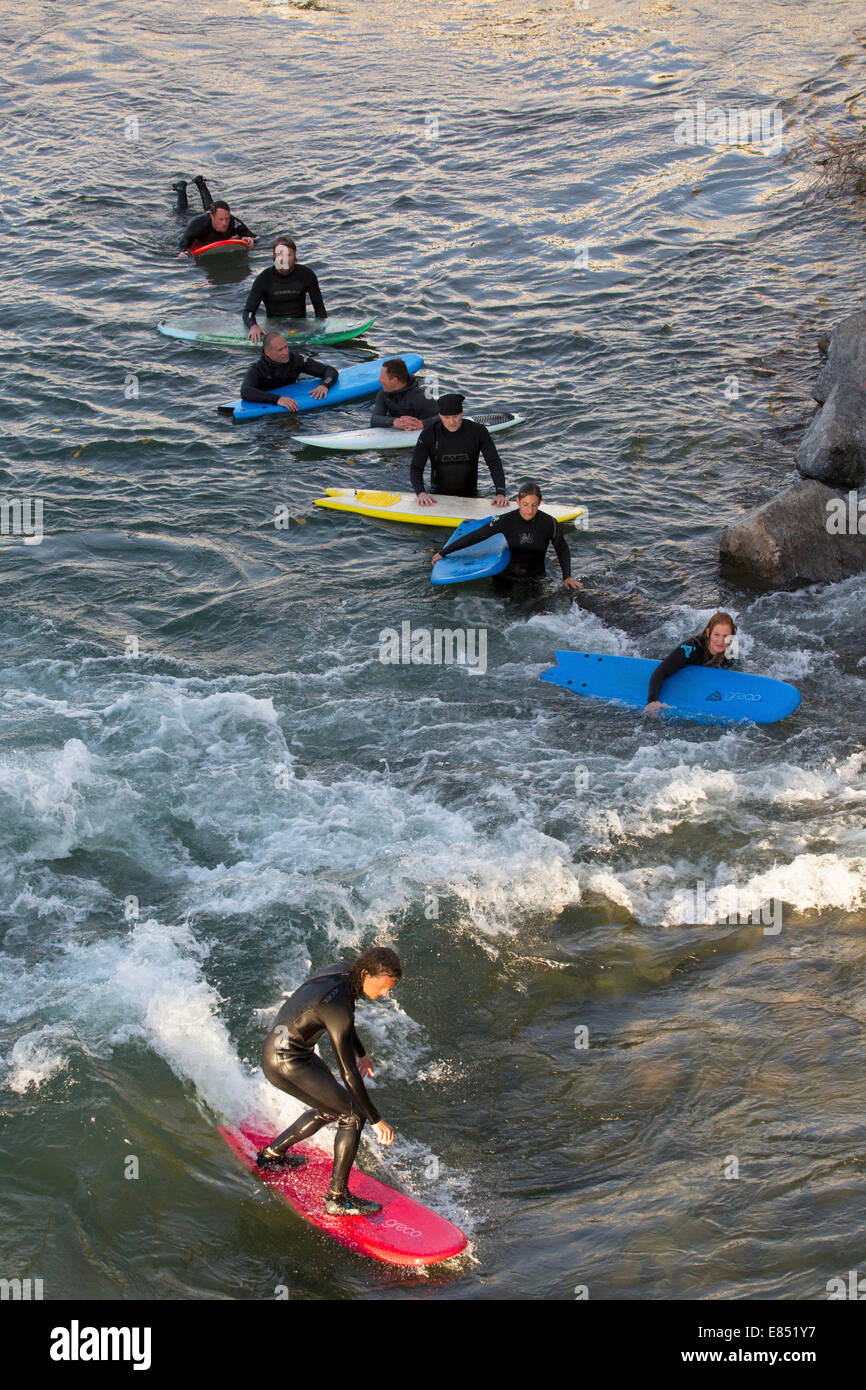 River surfers line up on the Bow River in downtown Calgary for stationary wave which was created by high floodwaters in 2013. Stock Photo