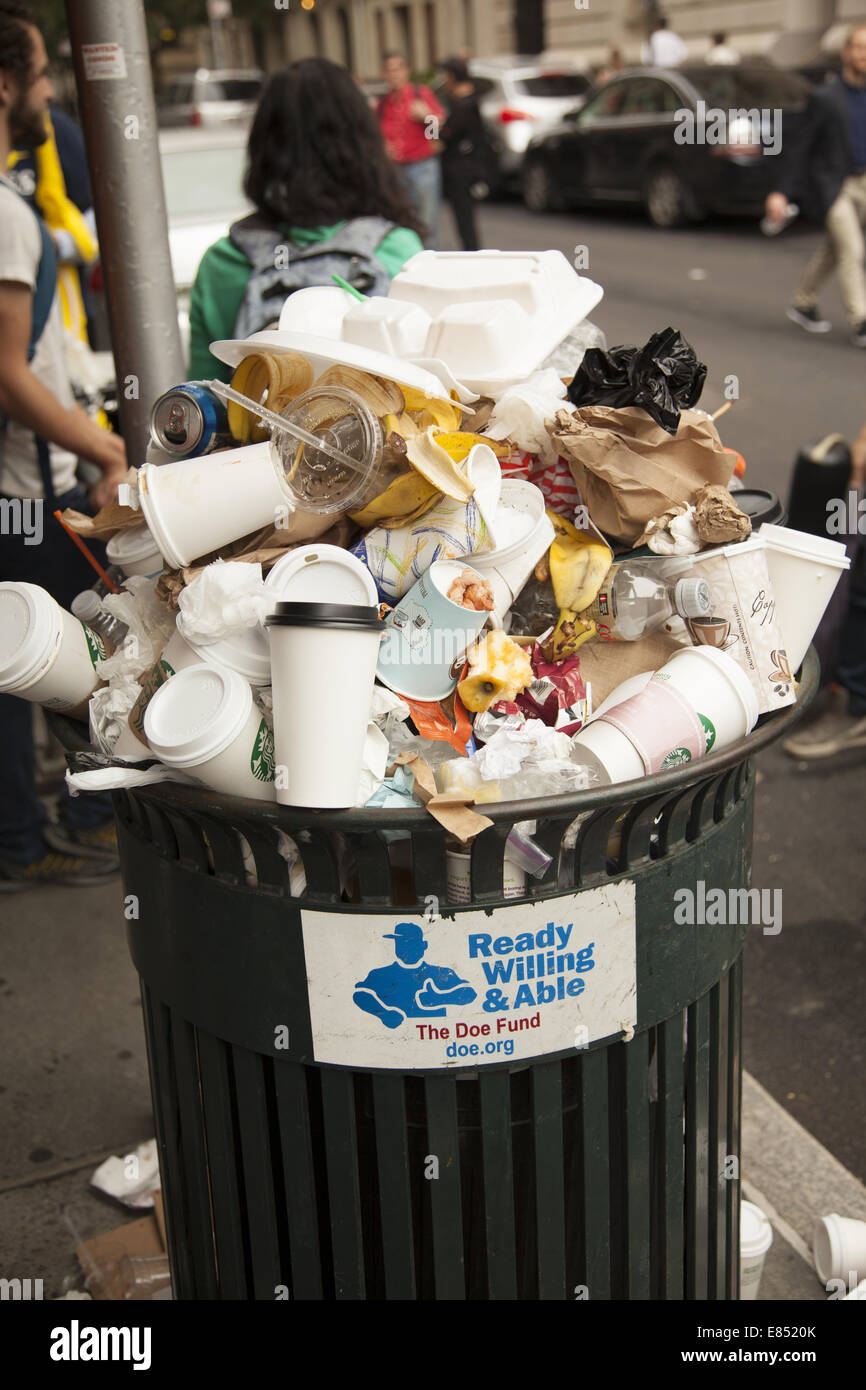 Overflowing trash can reflects the throwaway  fastfood culture we have created in the USA Stock Photo