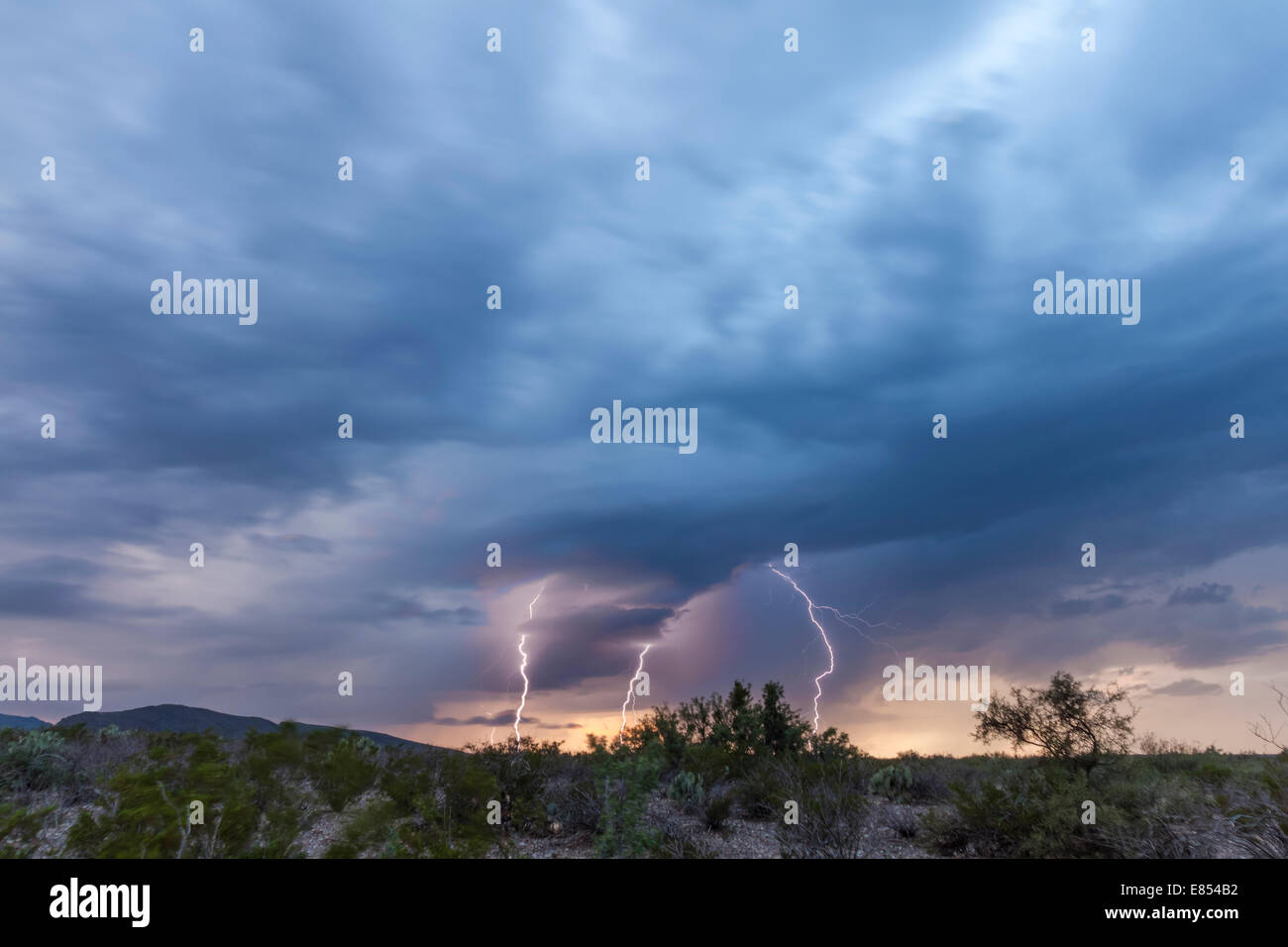 Storm clouds and Lightning strikes at Dugout Wells in Big Bend National Park. Stock Photo