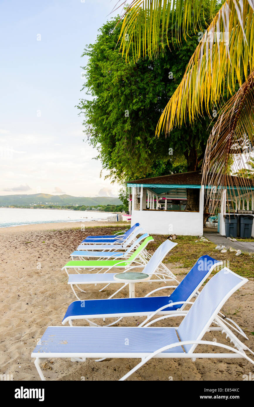 Beach chairs line up on the beach, west end, of St. Croix, U.S. Virgin Islands at dawn. Cottages by the Sea resort. Stock Photo