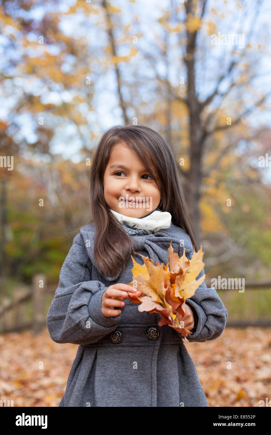 Little girl with autumn leaves in an autumn park Stock Photo - Alamy
