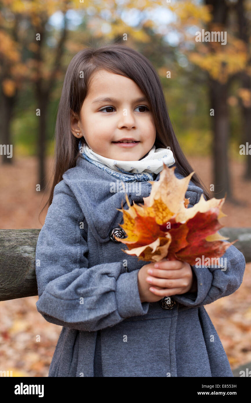 Little girl with autumn leaves in an autumn park Stock Photo - Alamy