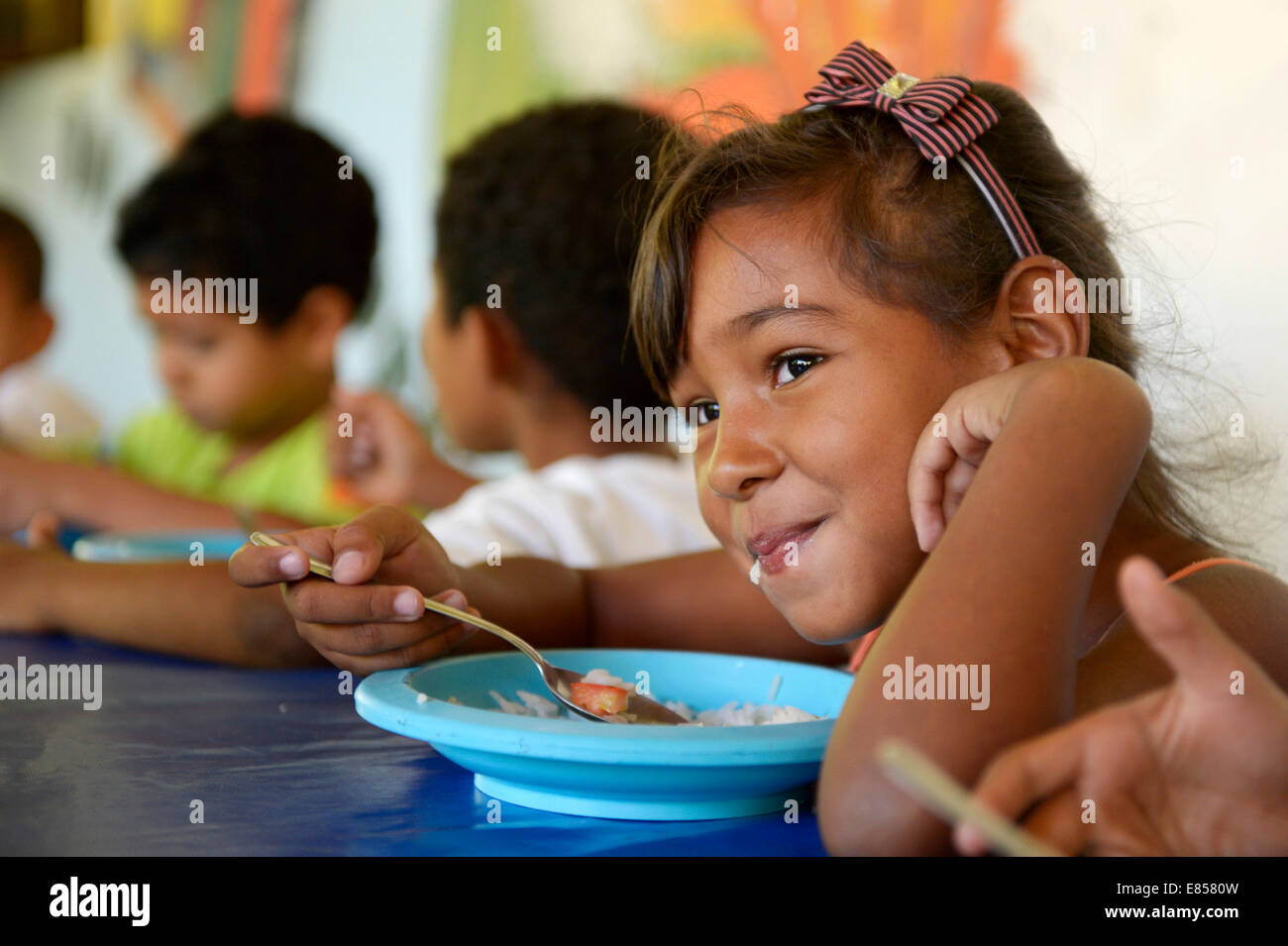 https://c8.alamy.com/comp/E8580W/girl-eating-in-the-canteen-of-a-social-project-ponta-da-serra-crato-E8580W.jpg