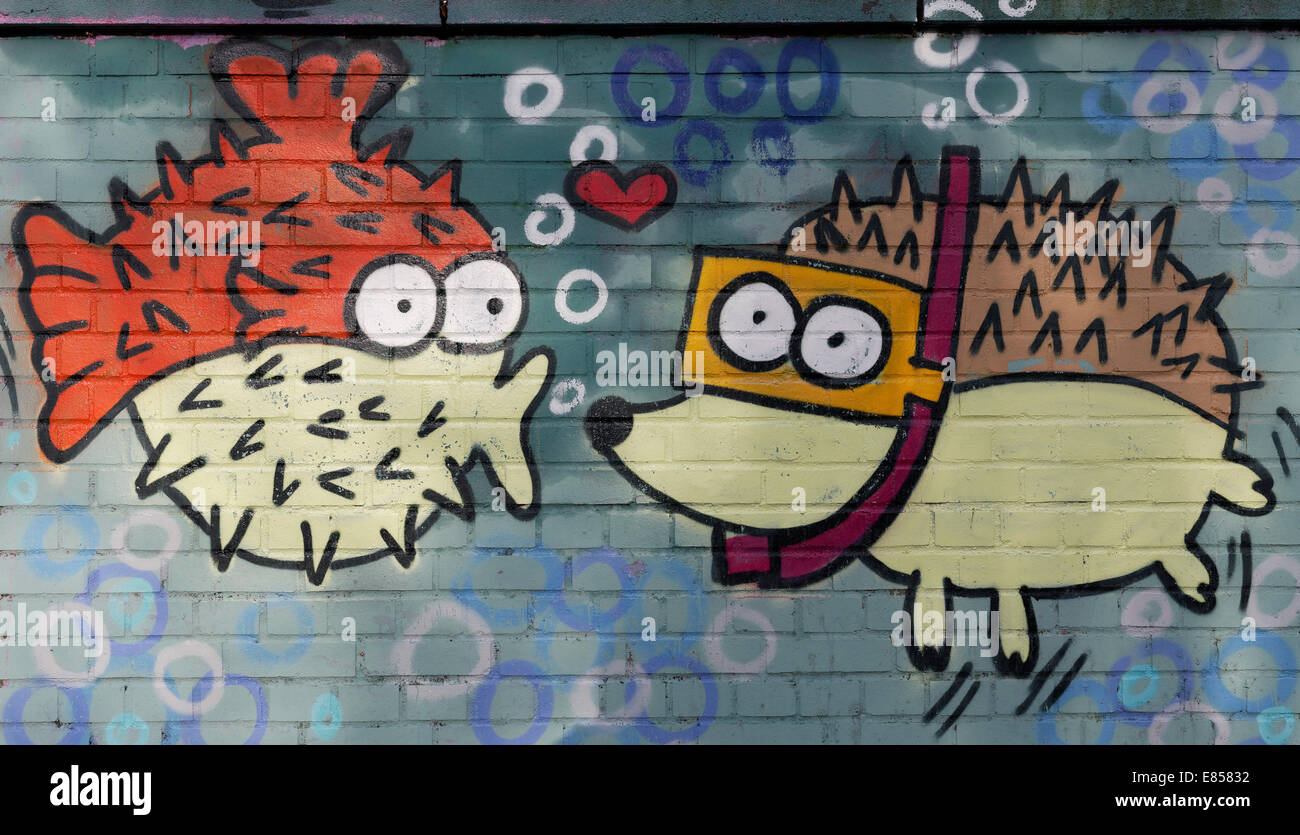 Spiny fish figure kissing a hedgehog figure wearing goggles, mural, North Rhine-Westphalia, Germany Stock Photo