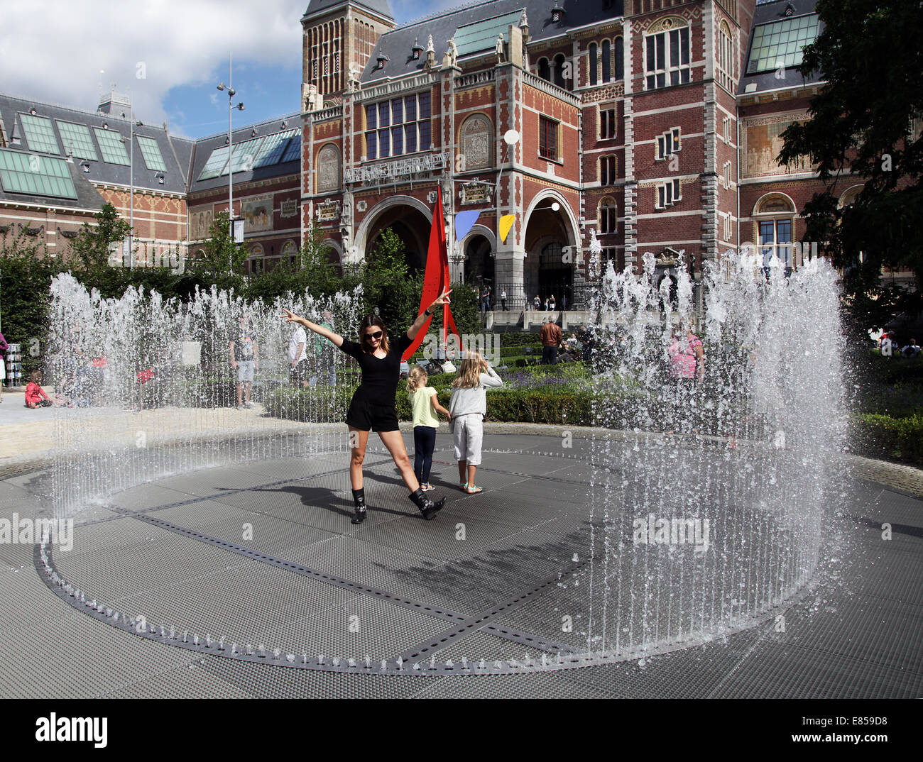 Girls having fun at the fauntain in the garden of the Rijksmuseum Amsterdam.Summer in Amsterdam !!! Stock Photo