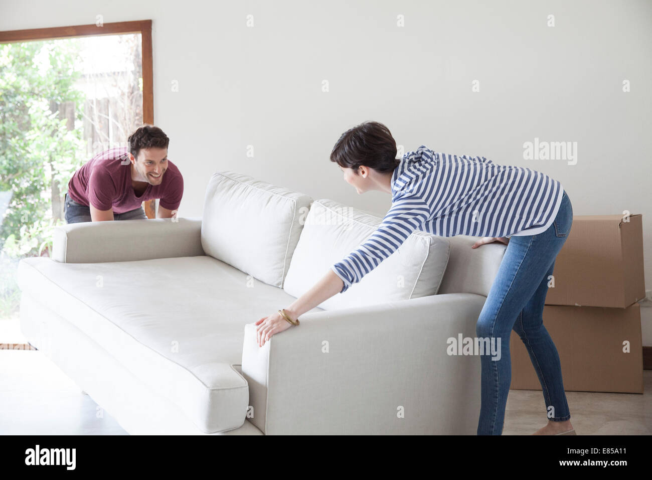 Couple moving sofa together Stock Photo
