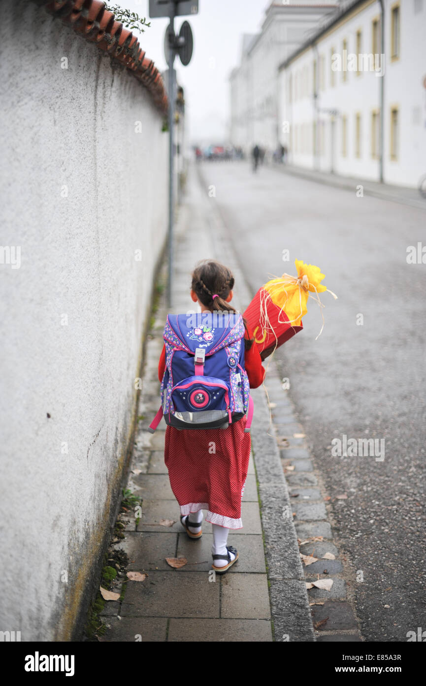 A little girl carries her "Schultuete" (literally = schoolbag) a