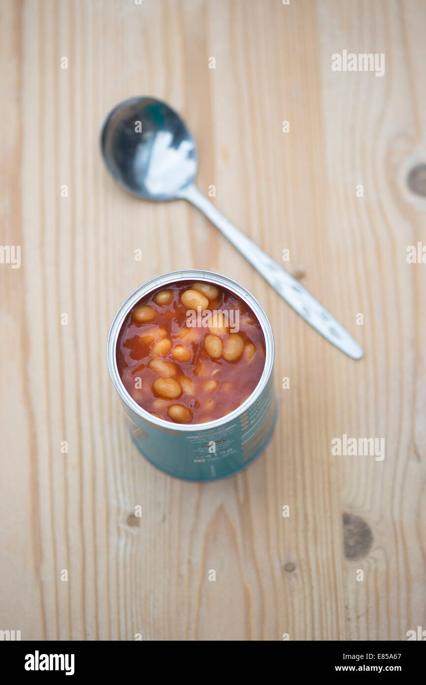 Open tin of Heinz Baked Beans and a spoon on a wooden table Stock Photo
