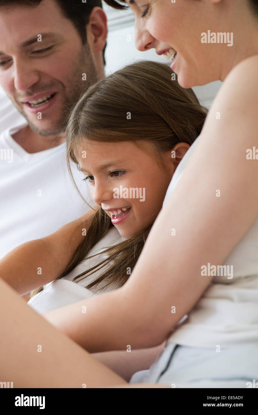 Parents and daughter reading together Stock Photo