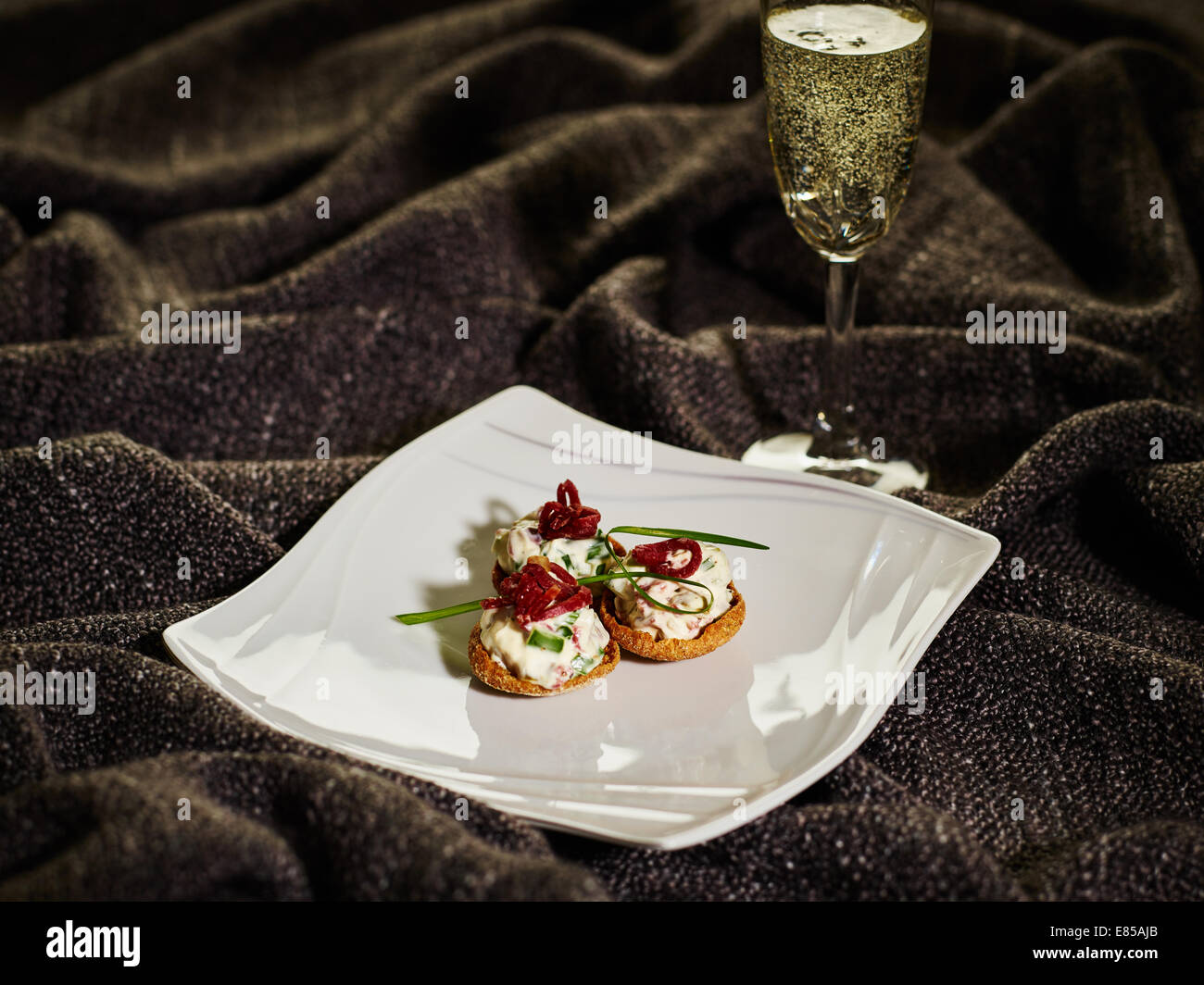 The appetizer, snacks on the plate and glass of the sparkling wine Stock Photo