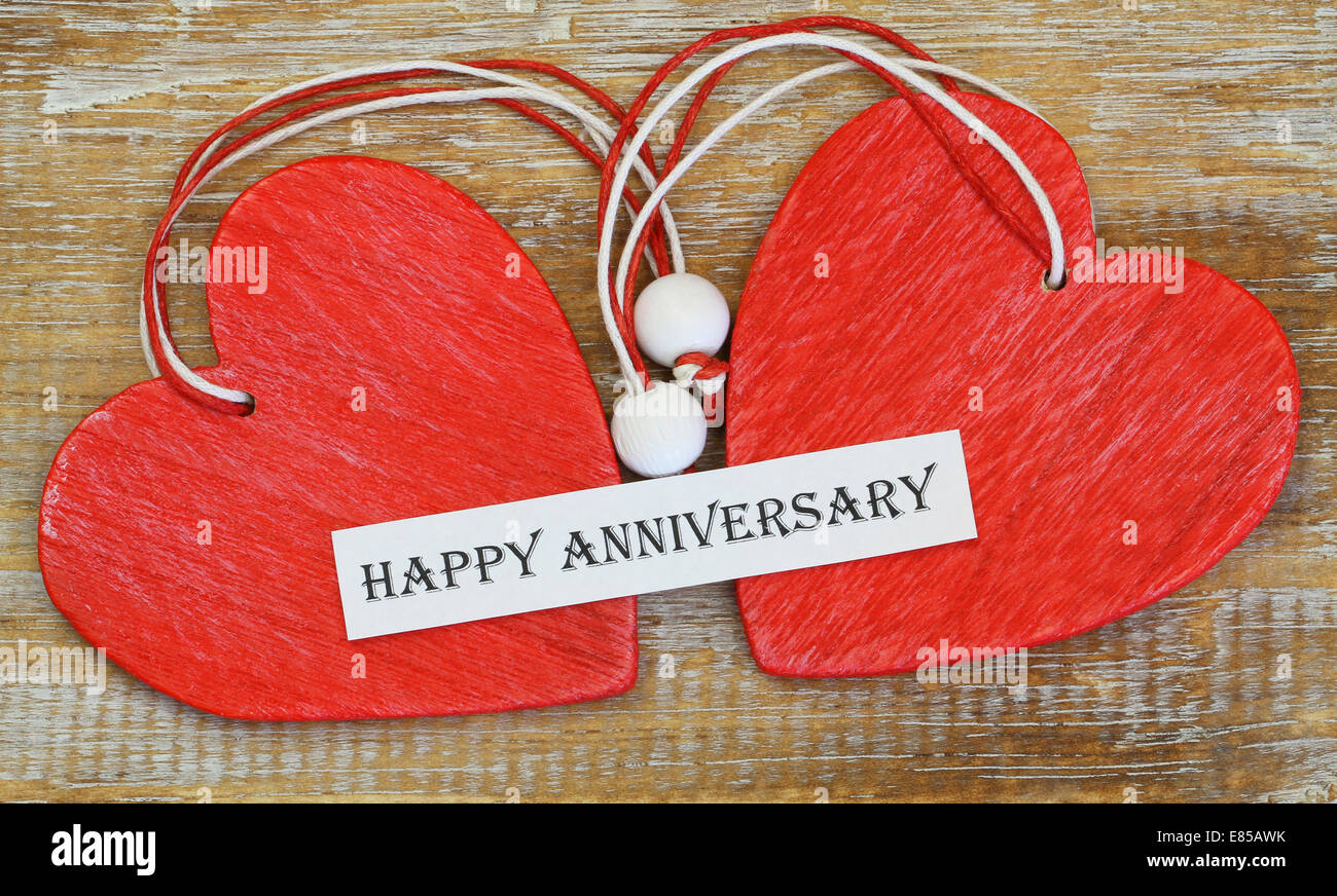 Happy Anniversary card with two red wooden hearts Stock Photo