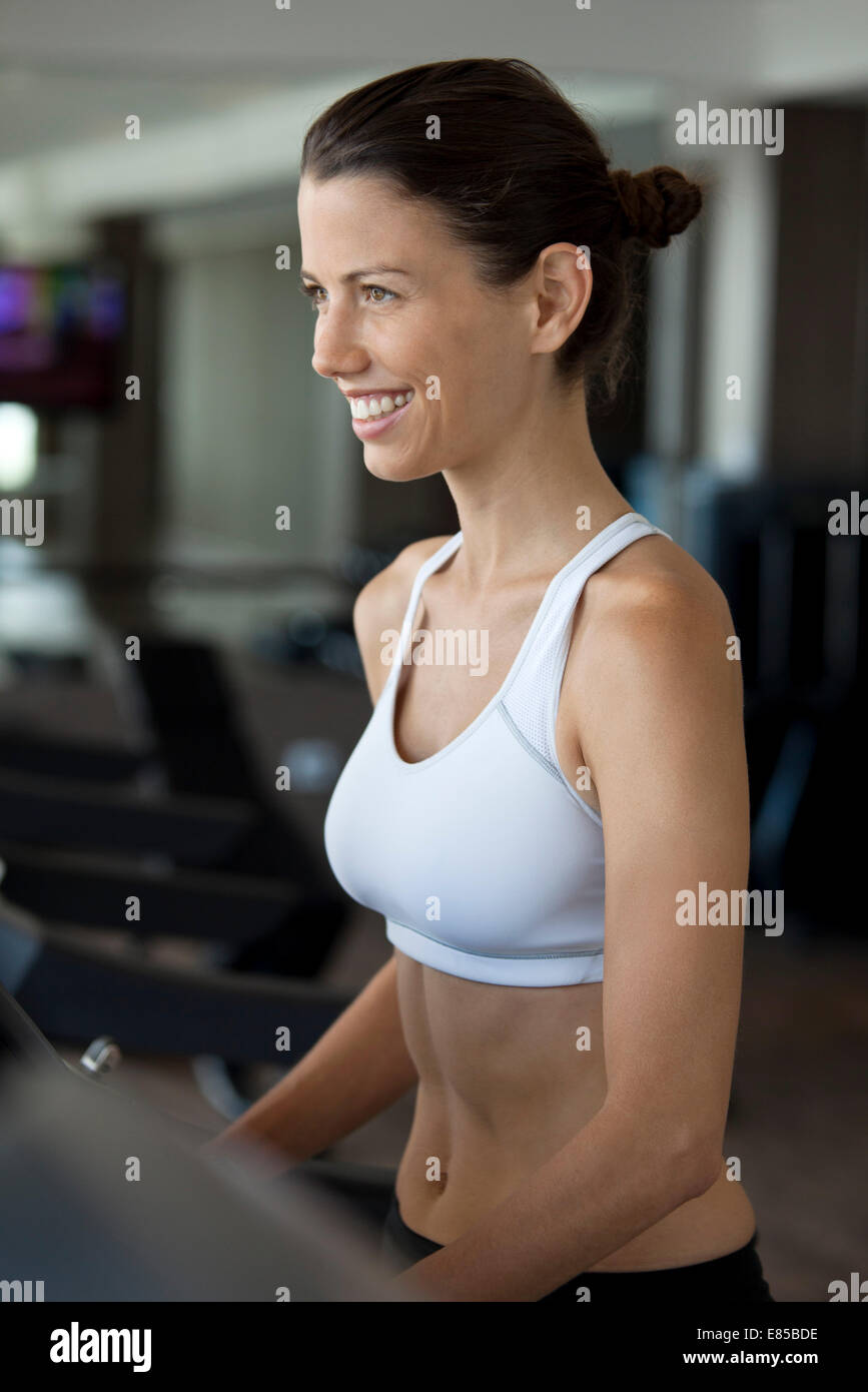 Woman exercising on treadmill in health club Stock Photo