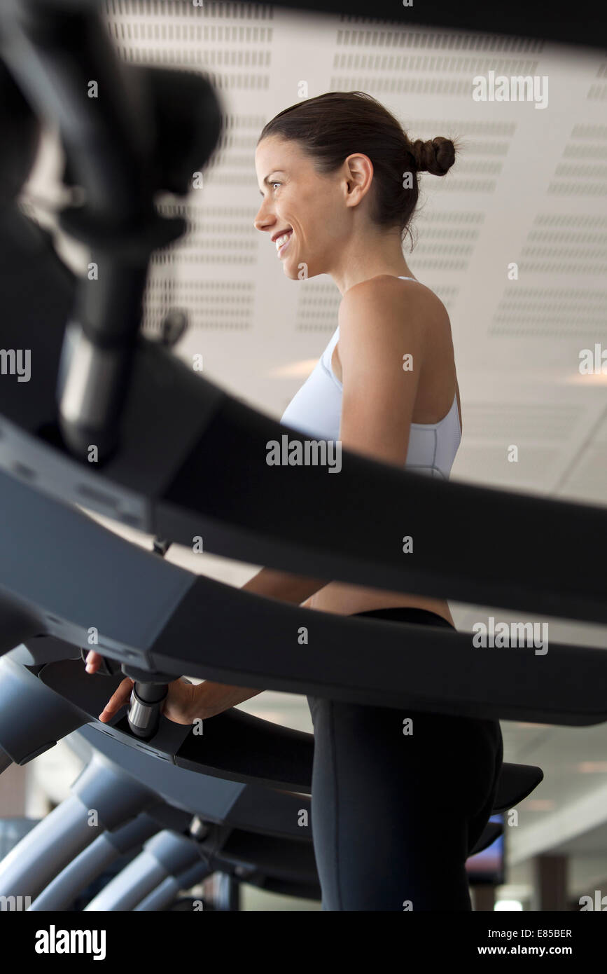 Woman using treadmill in health club Stock Photo