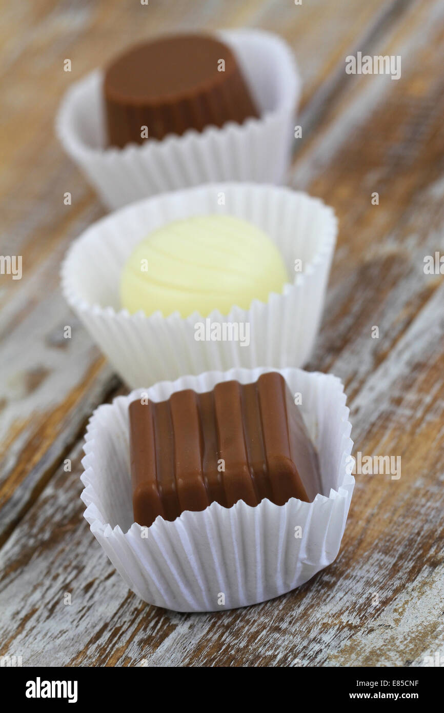 Assorted chocolates on wooden surface Stock Photo