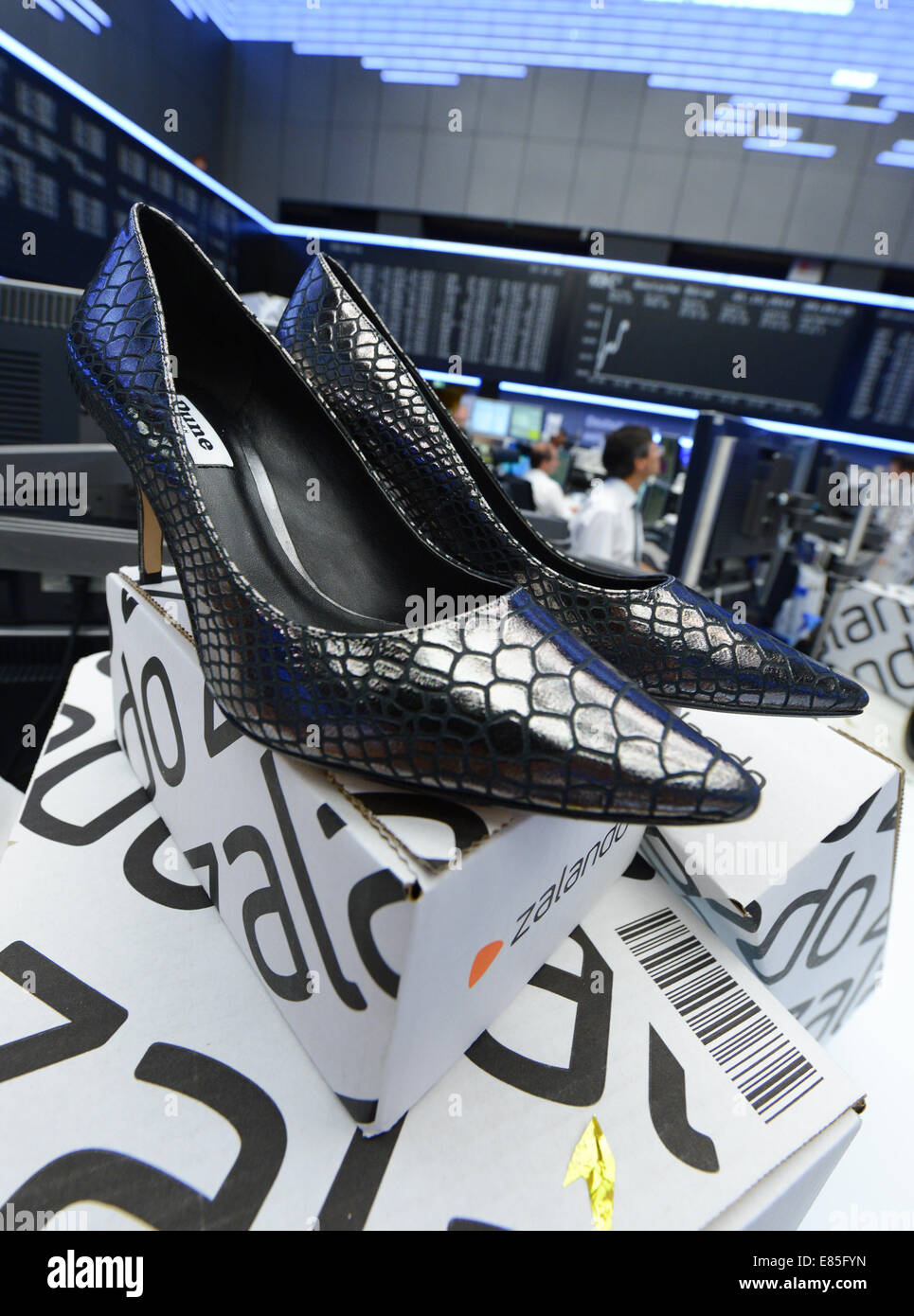 Frankfurt, Germany . 01st Oct, 2014. Zalando boxes and shoes stand in front  of the DAX display panel at the Frankfurt stock exchange during the stock  market launch ceremony of the mailorder