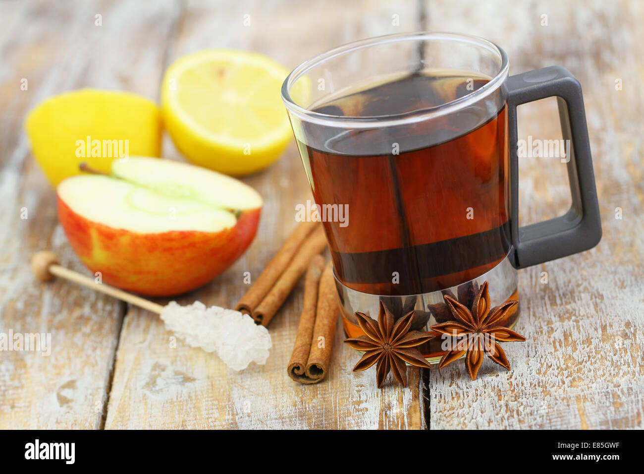 Glass of tea, star anise, cinnamon, apple and lemon Stock Photo