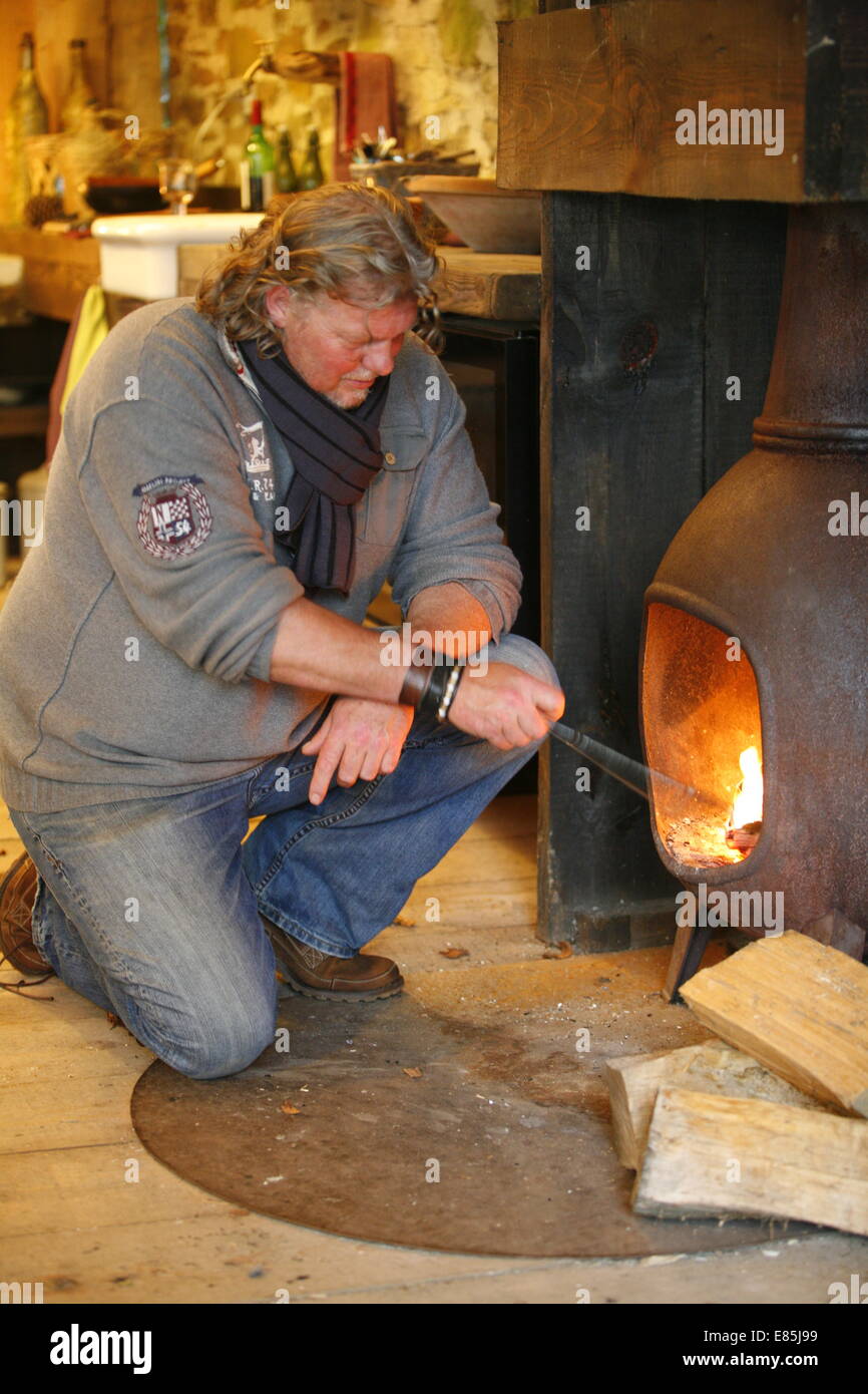 Man stoking a fire hires stock photography and images Alamy