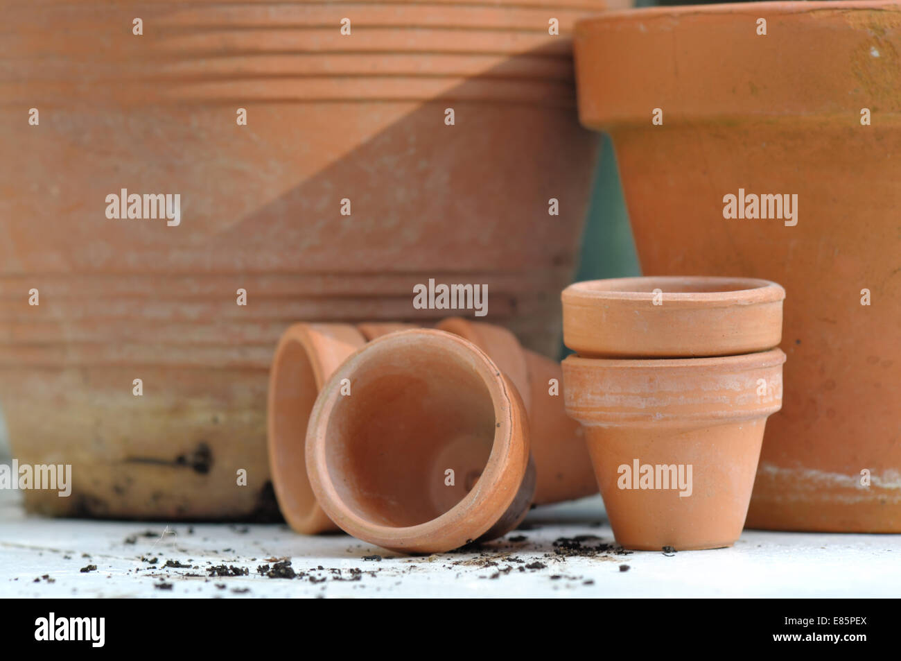 different sizes of terracotta pots on outdoor table Stock Photo