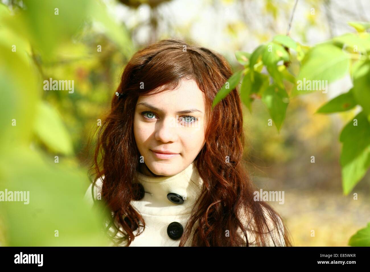 Portrait of a redheaded girl near a tree Stock Photo - Alamy