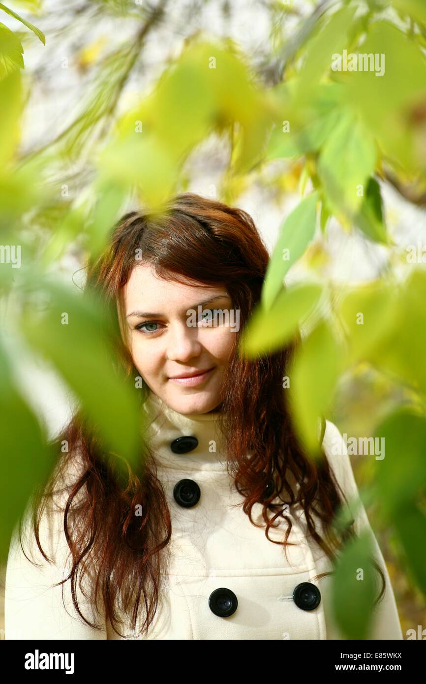 Portrait of a redheaded girl near a tree Stock Photo - Alamy