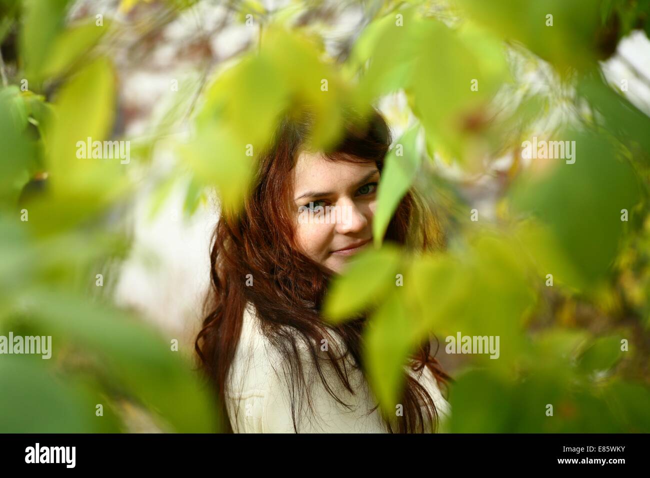 Portrait of a redheaded girl near a tree Stock Photo - Alamy