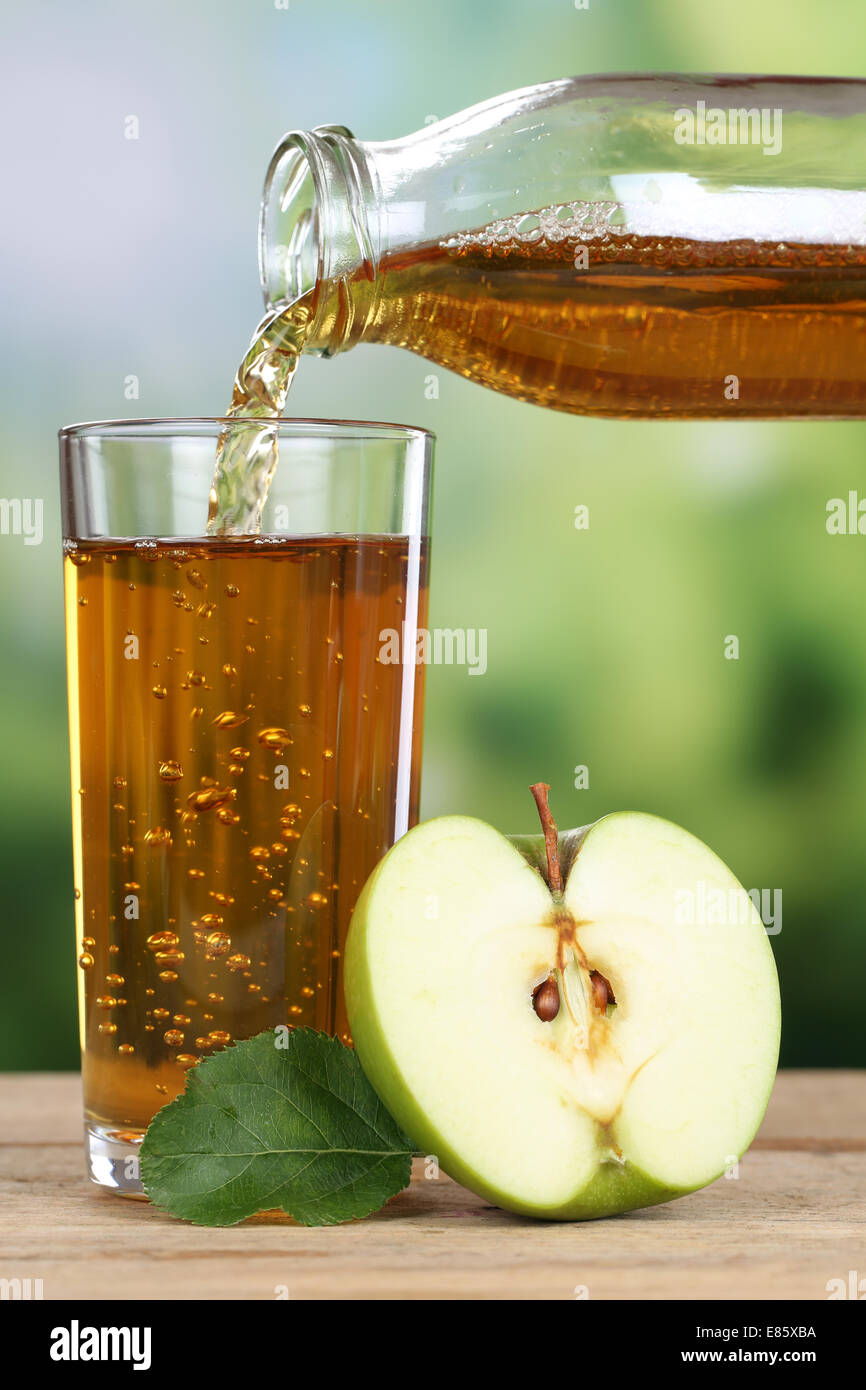 Healthy drinking apple juice pouring from apples fruits in autumn into a glass Stock Photo