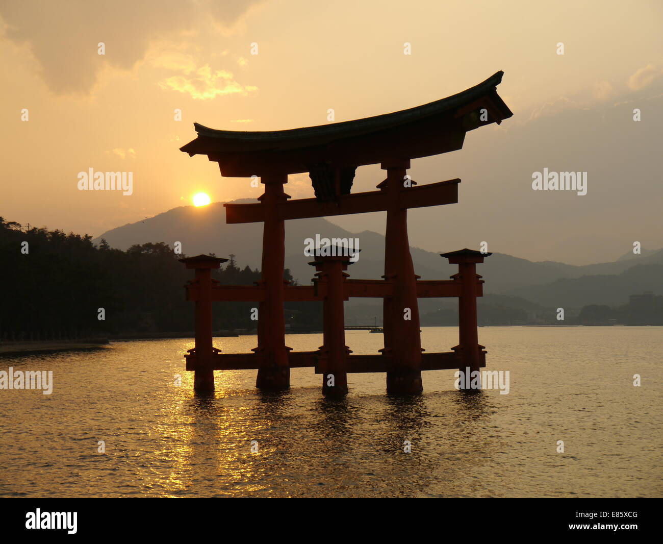 The torii gate on Miyajima island, part of the Itsukushima Shrine as the sun sets Stock Photo