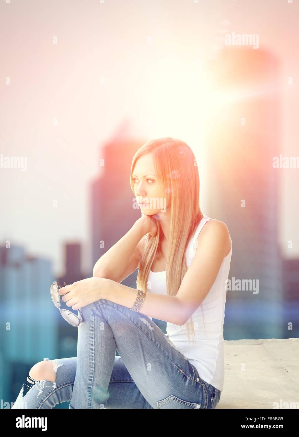 Outdoor photo of pretty girl sitting on the floor Stock Photo - Alamy