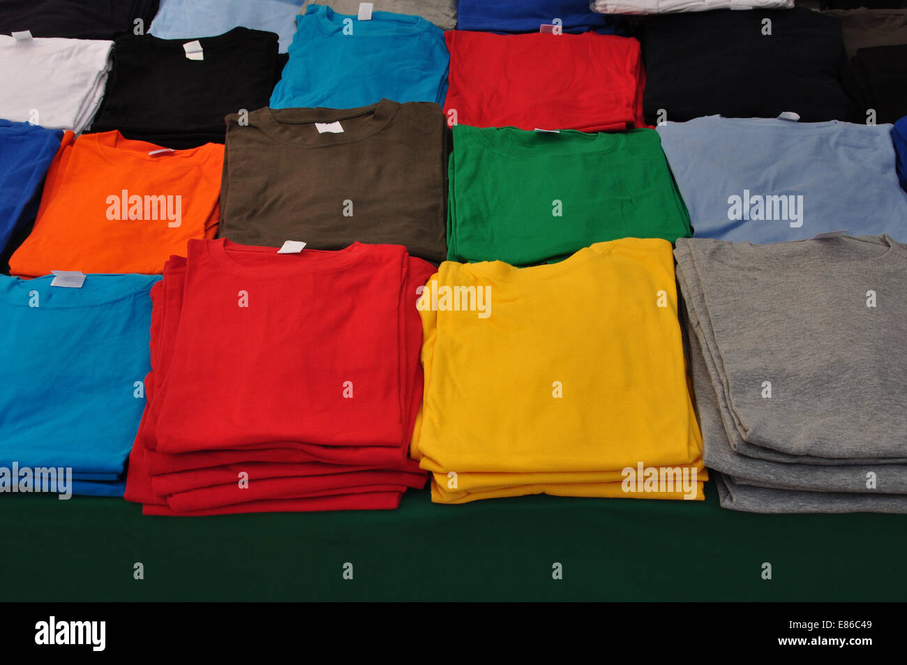 Cotton short sleeve t-shirts folded colorful clothes background. Stock Photo