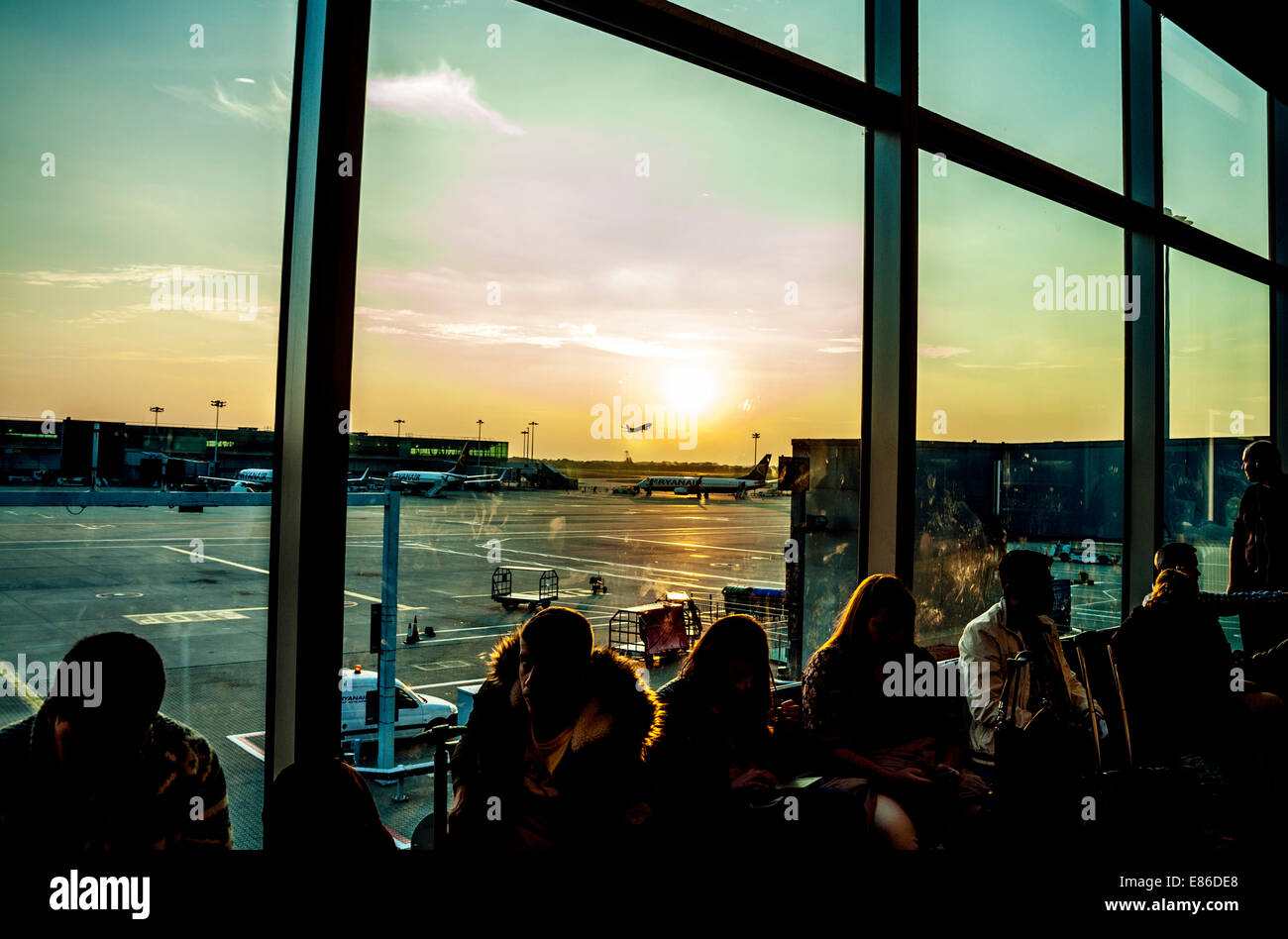 Passengers waiting to board aircraft in departure lounge at Stansted Airport UK Stock Photo