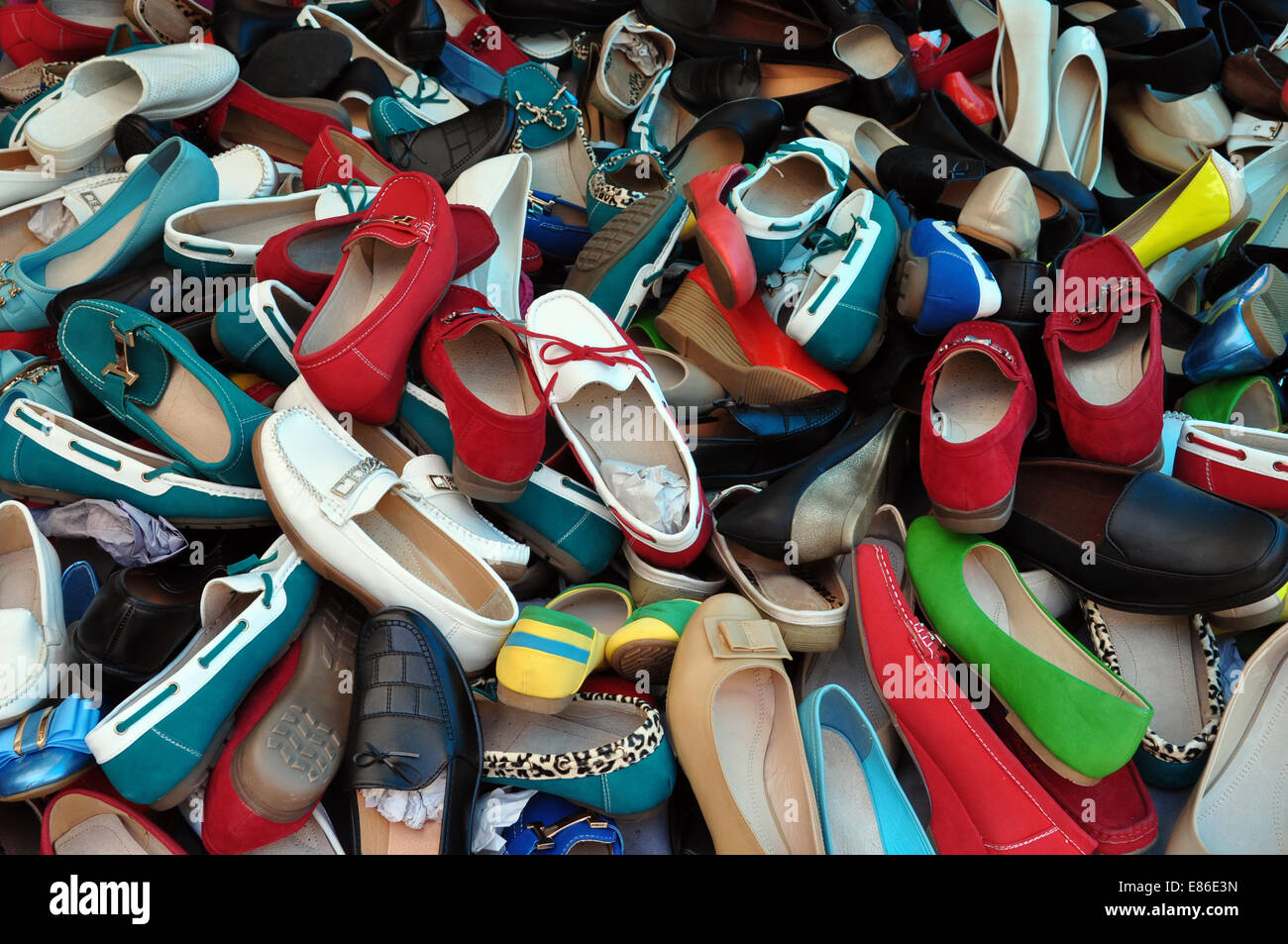Shoes for sale at street market. Pile of assorted footwear abstract background. Stock Photo