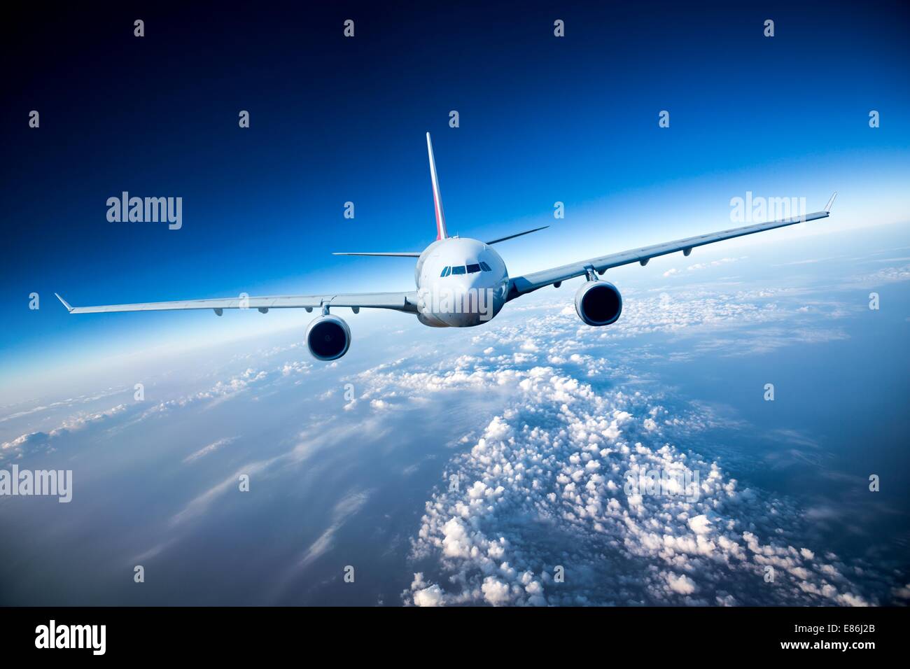 Passenger Airliner flying in the clouds Stock Photo - Alamy