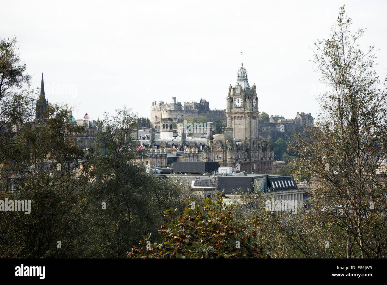Edinburgh Castle and the Balmoral Hotel framed by trees. Stock Photo