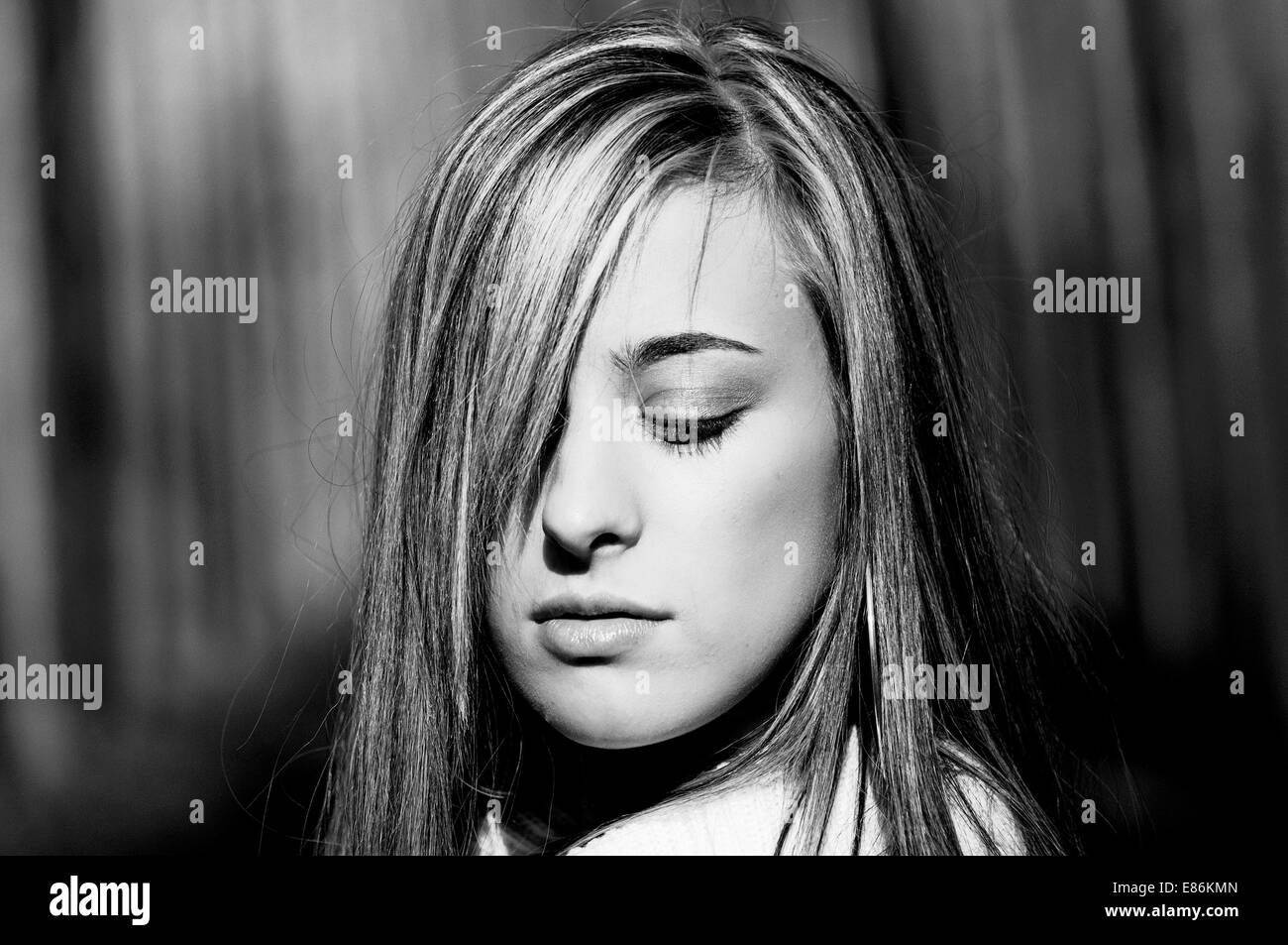 Beautiful blonde girl, dressed with a beige dress, standing in a poplar