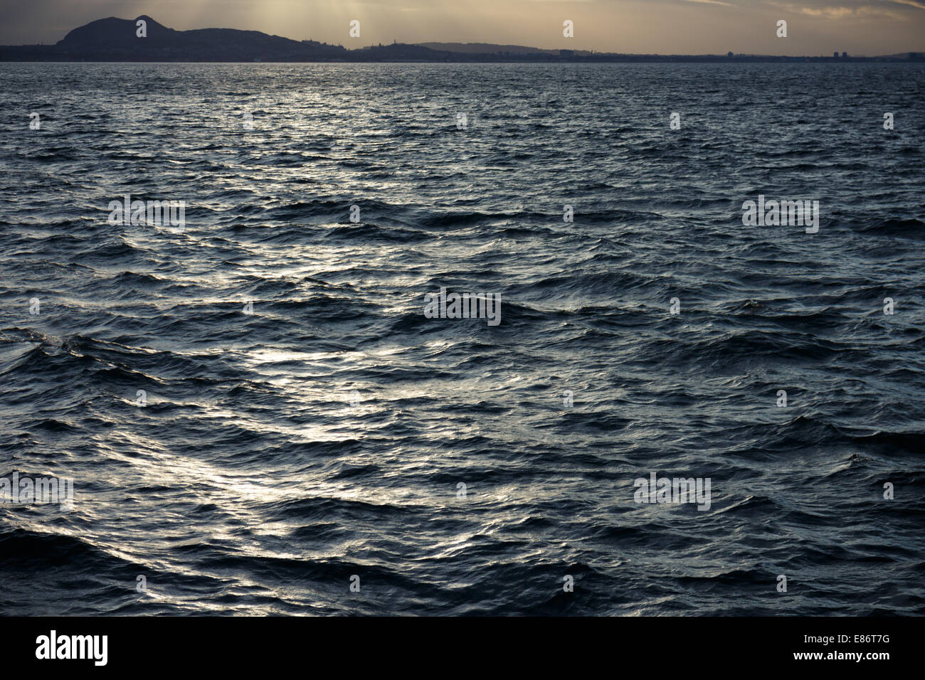 Dark sea water of the Firth of Forth with Edinburgh on the horizon Stock Photo