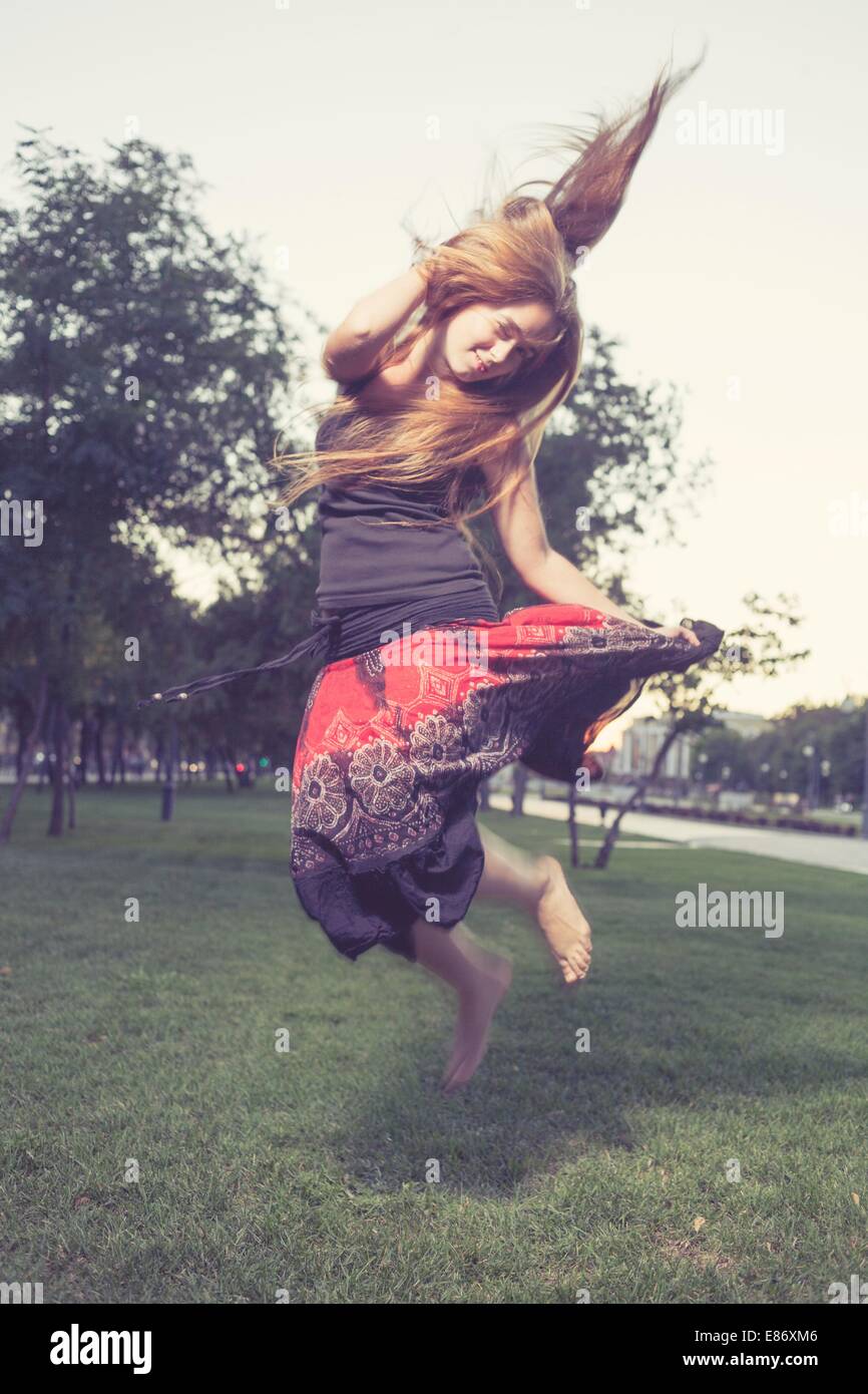 Girl jumping like flying bird. Hair by the wind. Stock Photo