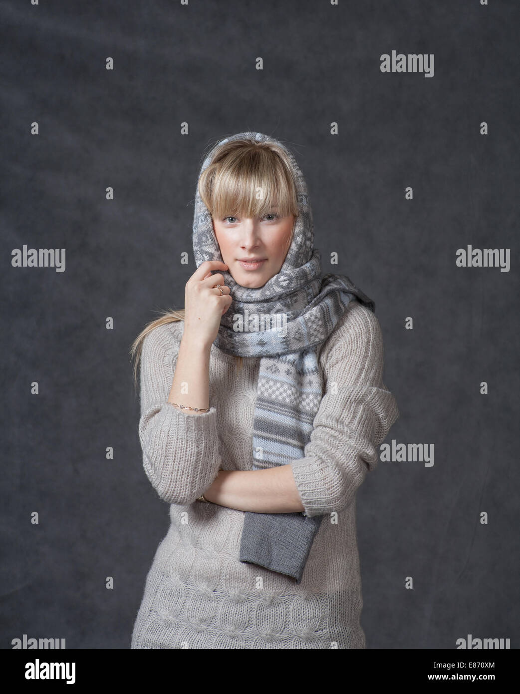Portrait of woman on dark background wearing woolen accessories Stock Photo